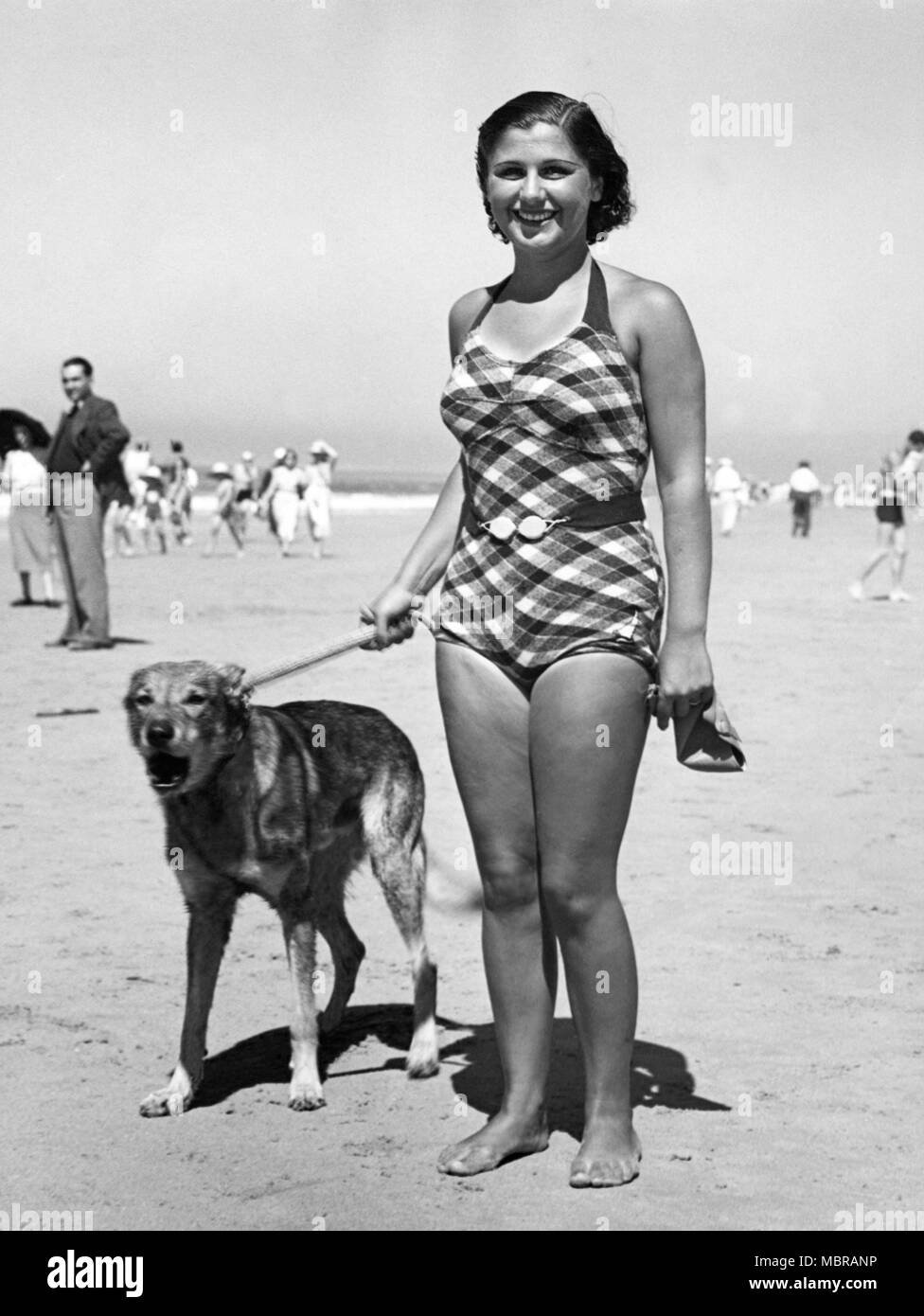 Woman in bathing suit with dog on the beach, 1940s, North Sea, Germany Stock Photo