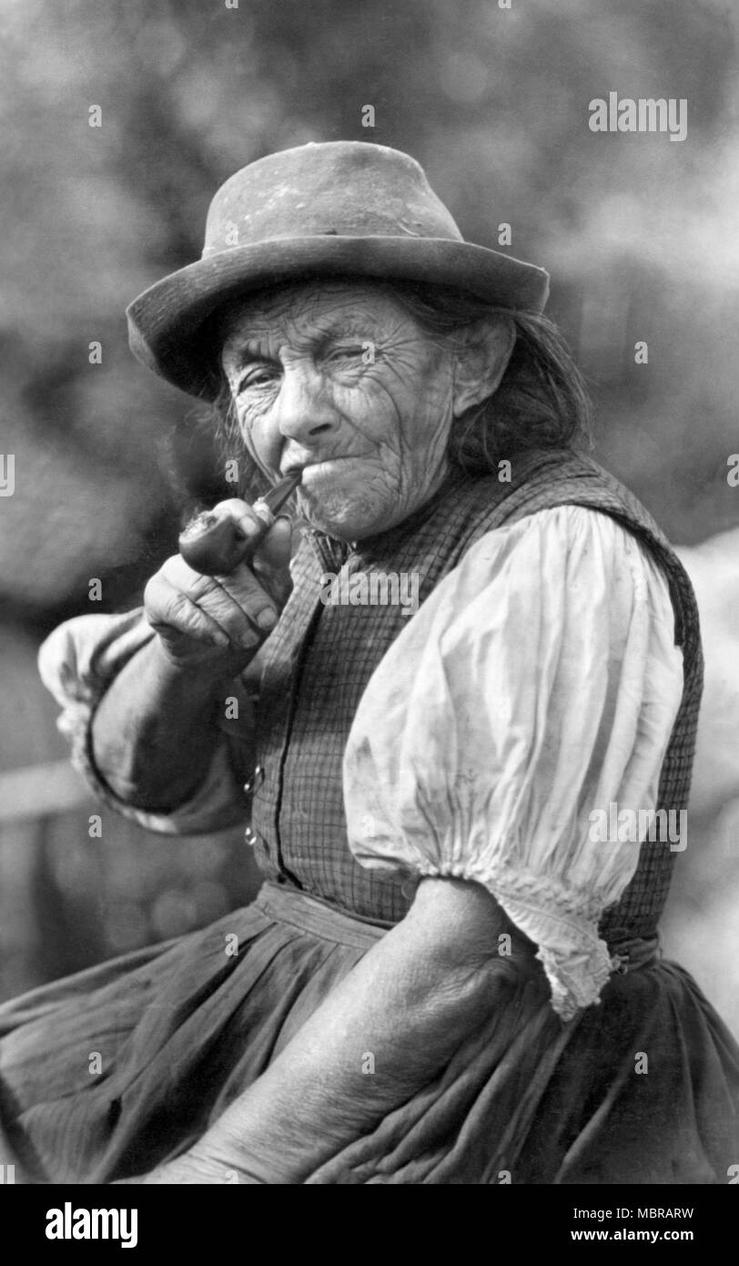 Portrait of an old woman smoking a pipe, the Plattenweible, 1930s, Germany  Stock Photo - Alamy
