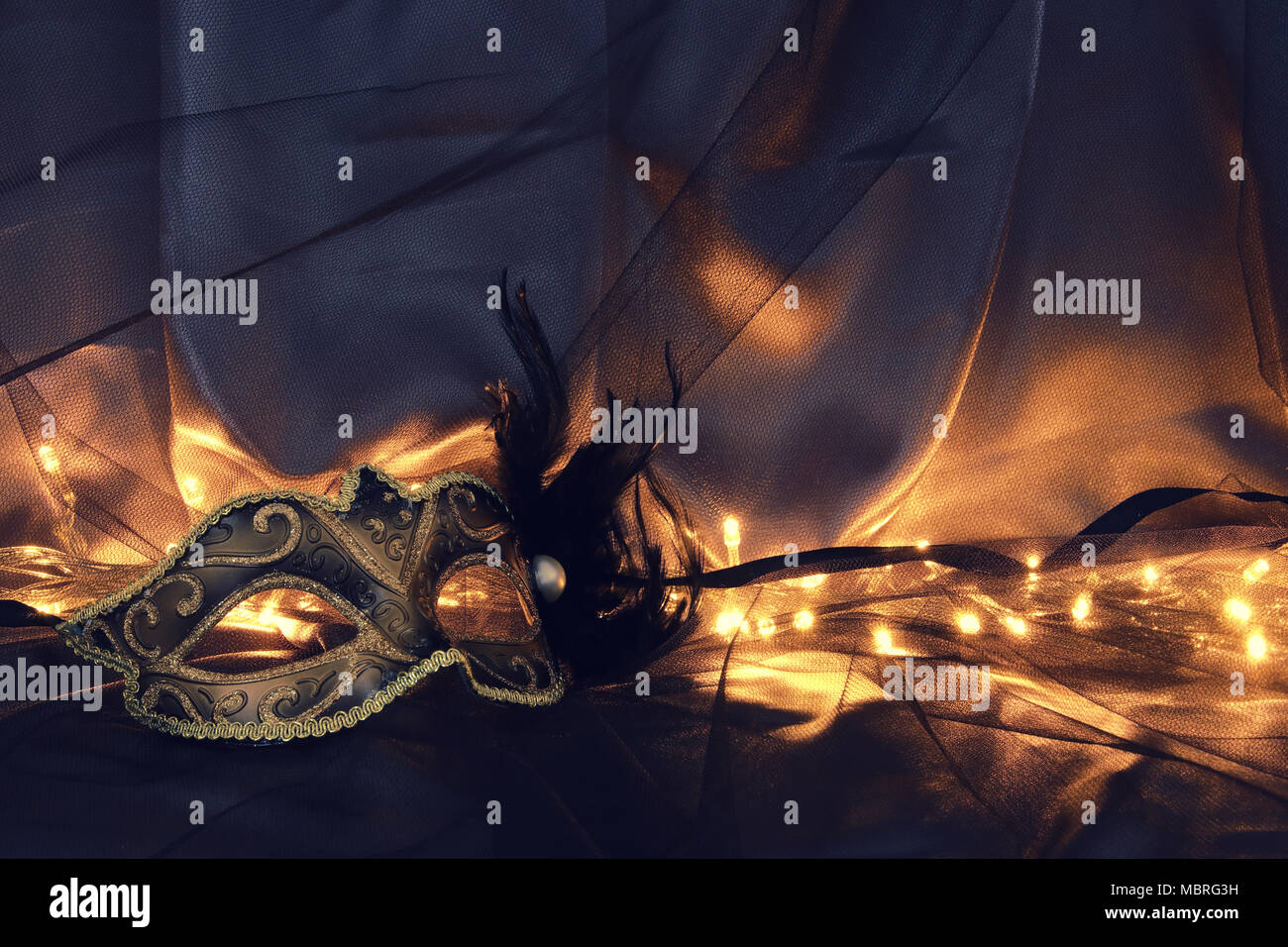 Image of elegant gold and black venetian mask over tulle background ...