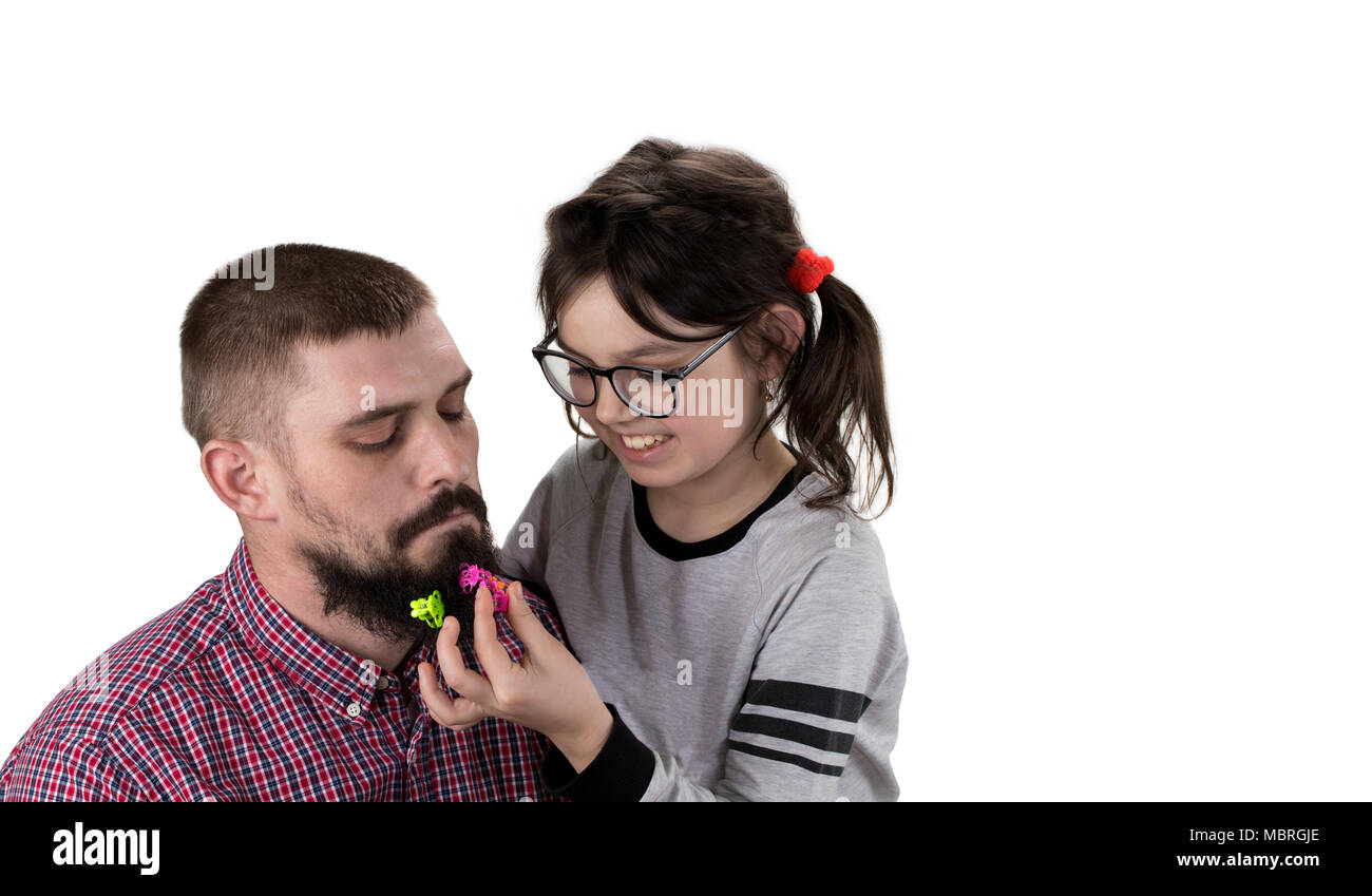 Father and daughter playing together. Girl is playing with her dad and making his hairstyle. Isolated on white. Stock Photo