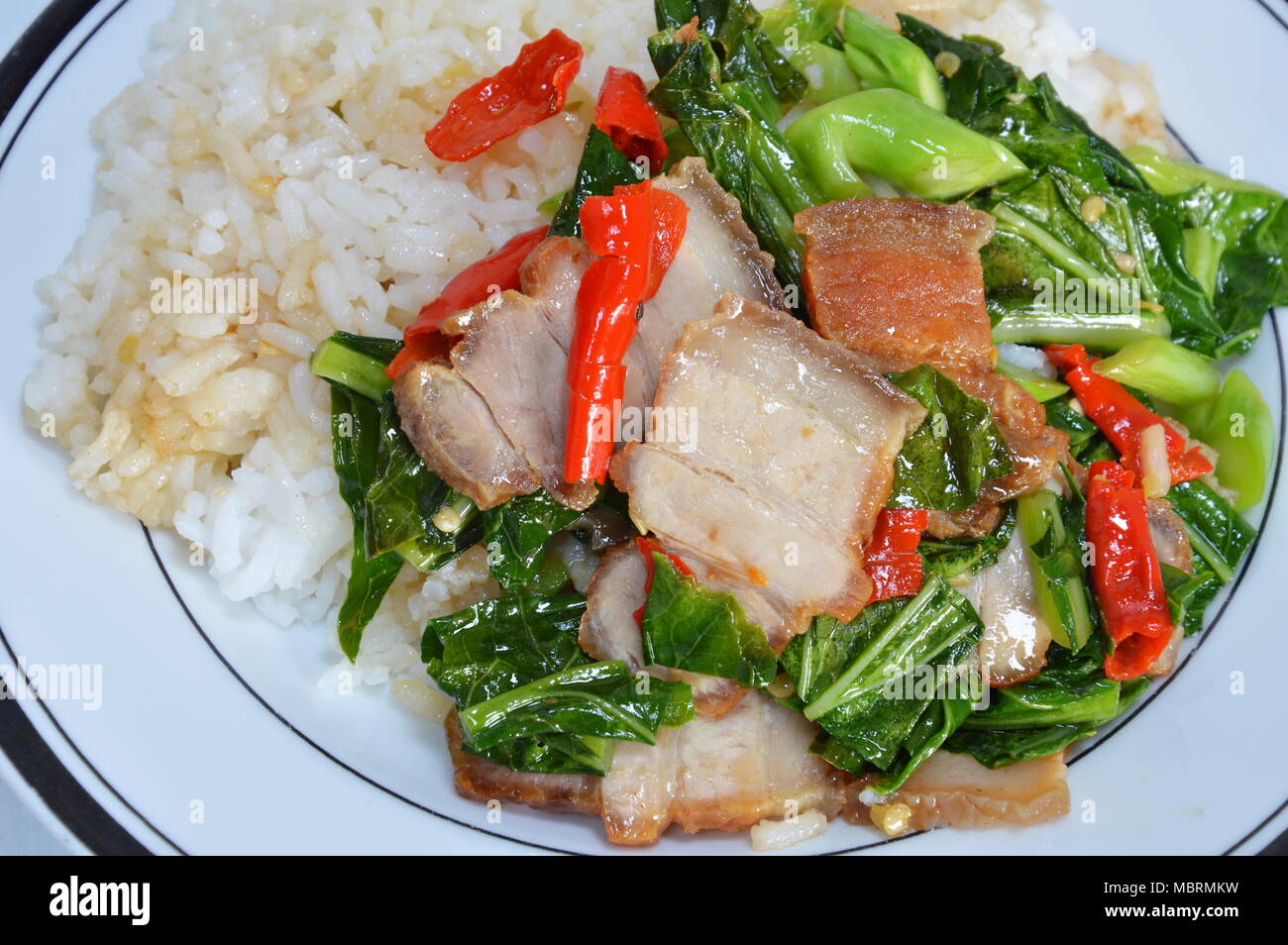 stirfried Chinese kale with crispy pork and chili Stock Photo Alamy