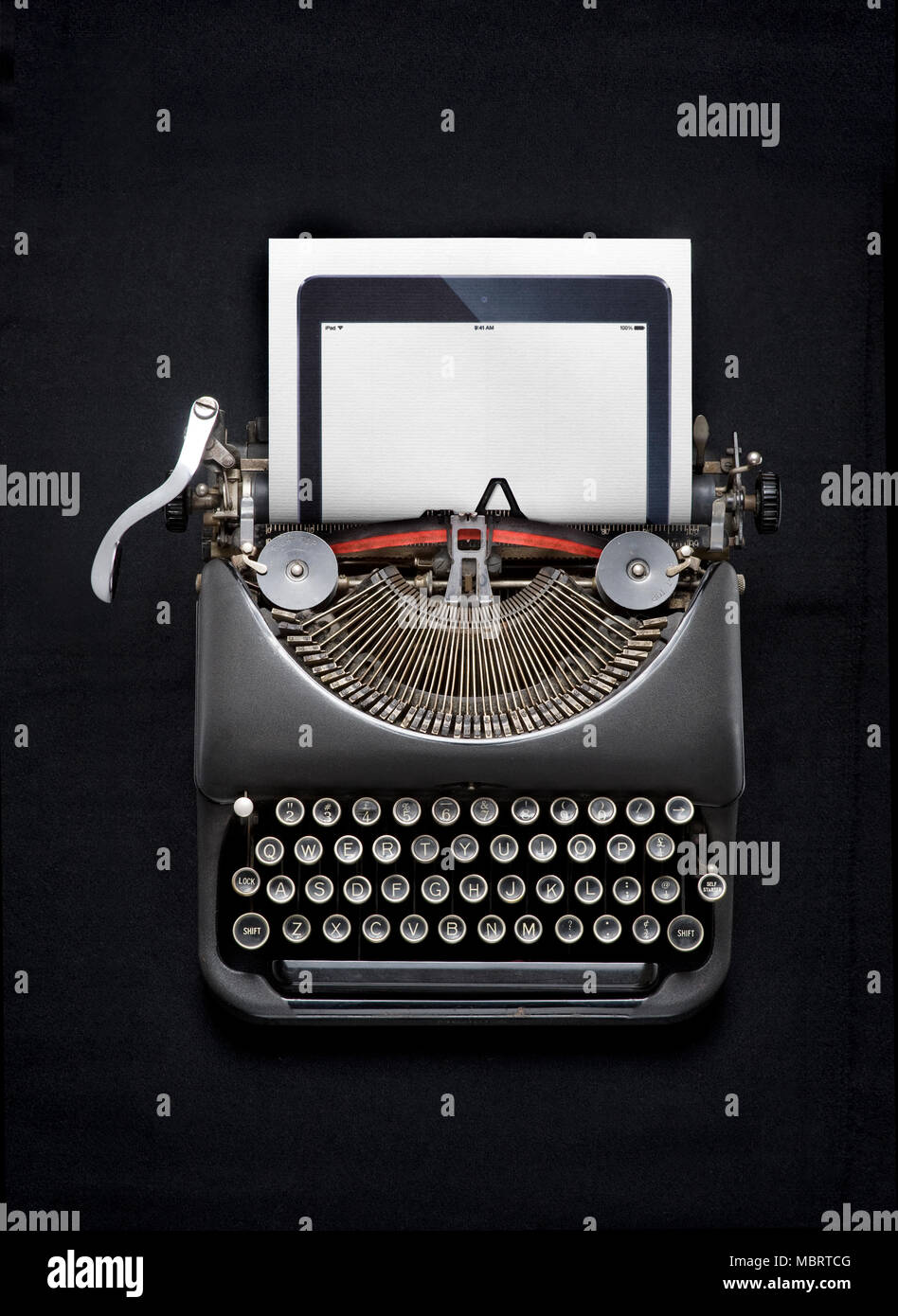A tablet computer and a typewriter Stock Photo