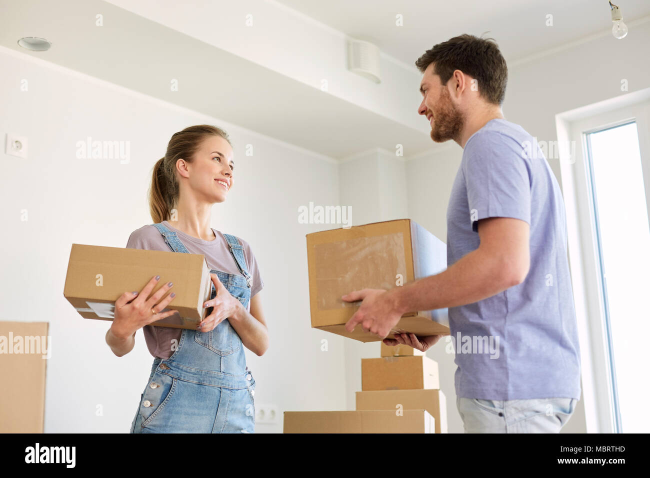 happy couple with boxes moving to new home Stock Photo - Alamy