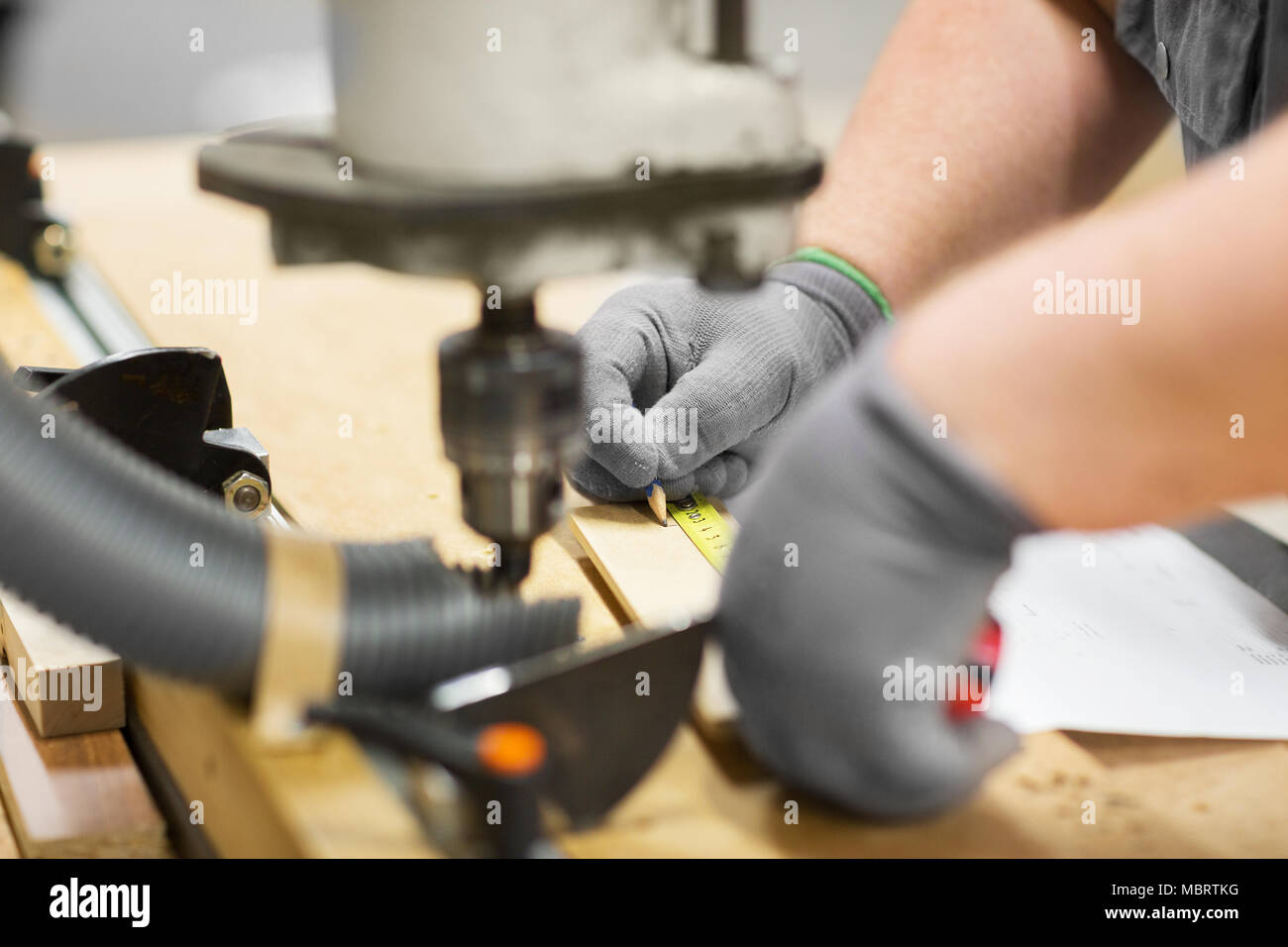 carpenter with ruler measuring board at workshop Stock Photo