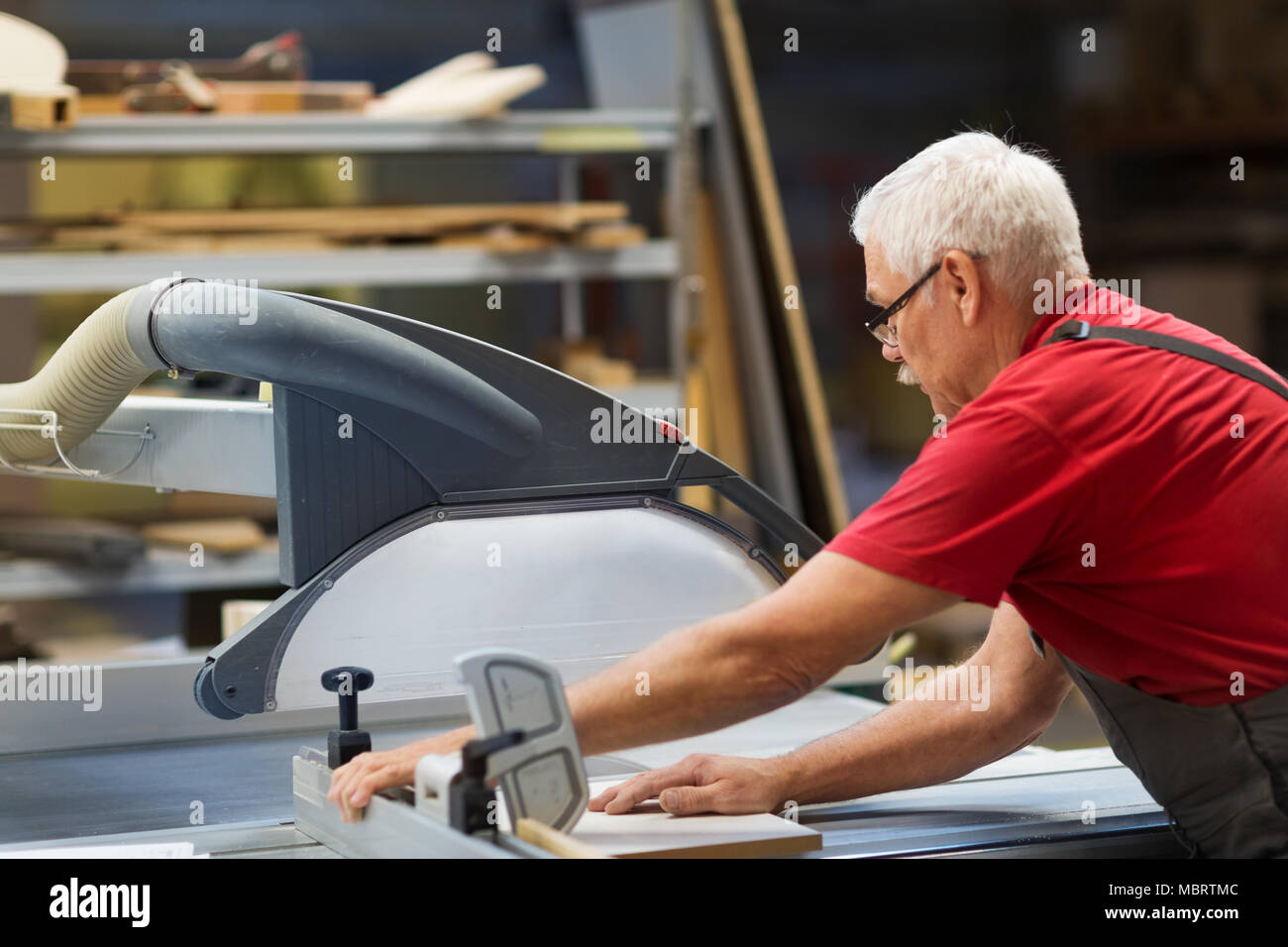 carpenter with panel saw and fibreboard at factory Stock Photo