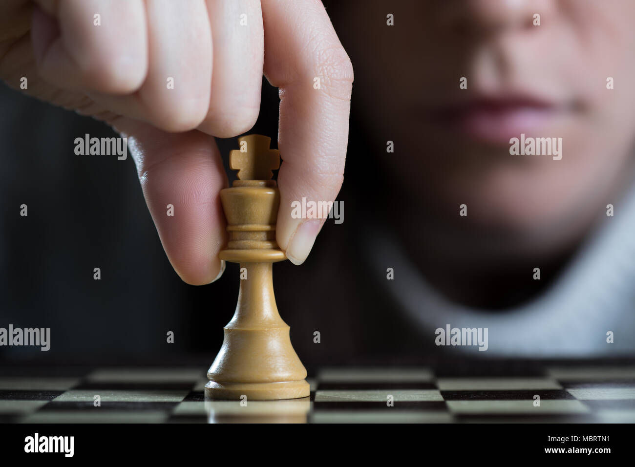 Detail of a Woman Playing Chess Moving the White King Stock Photo