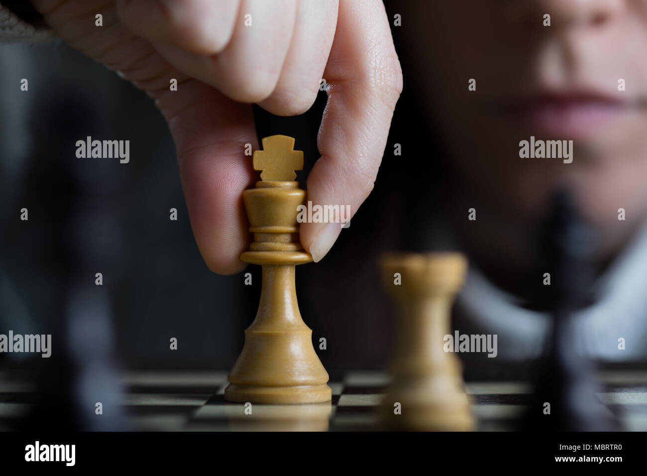 Detail of a Woman Playing Chess Moving the White King Stock Photo