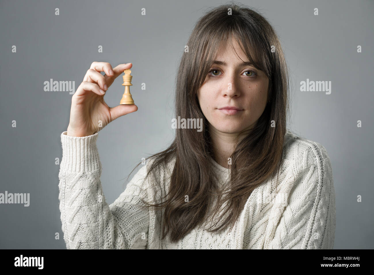 Young Woman Holding a King Chess Piece with Her Hand Stock Photo