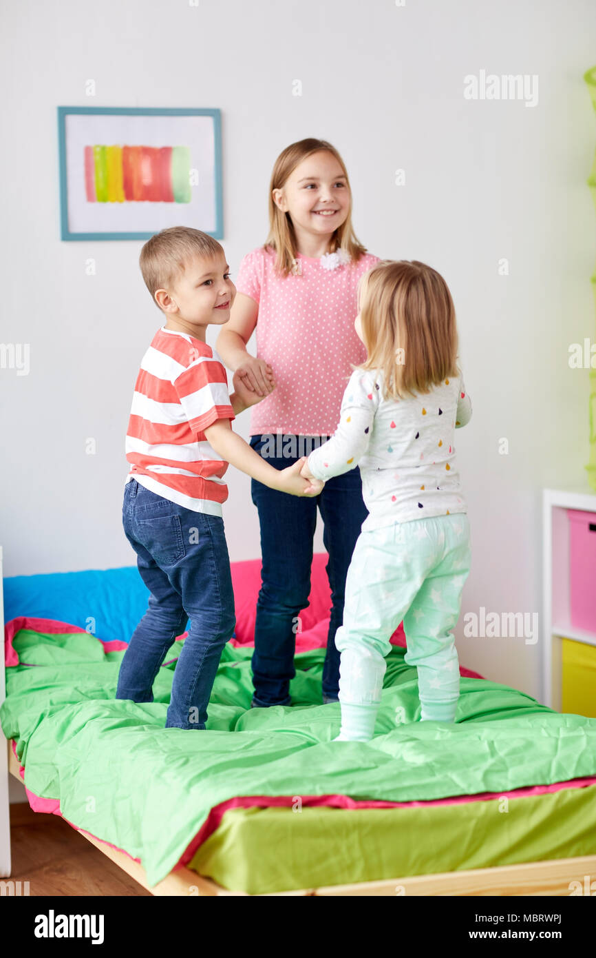 happy little kids jumping on bed at home Stock Photo Alamy
