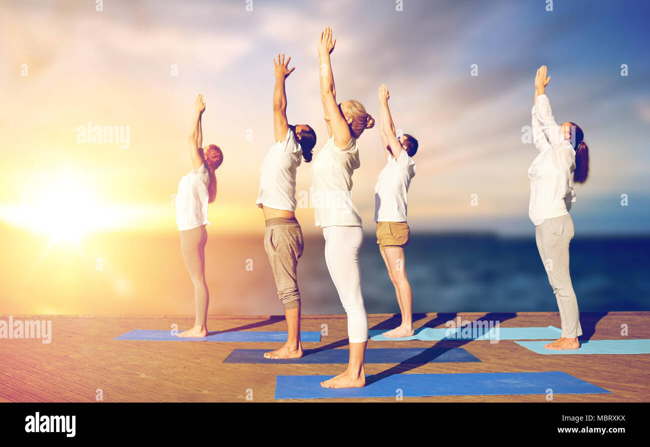 group of people doing yoga outdoors Stock Photo