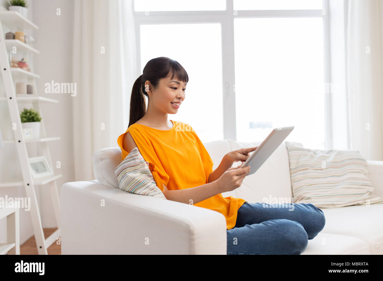 happy young asian woman with tablet pc at home Stock Photo - Alamy