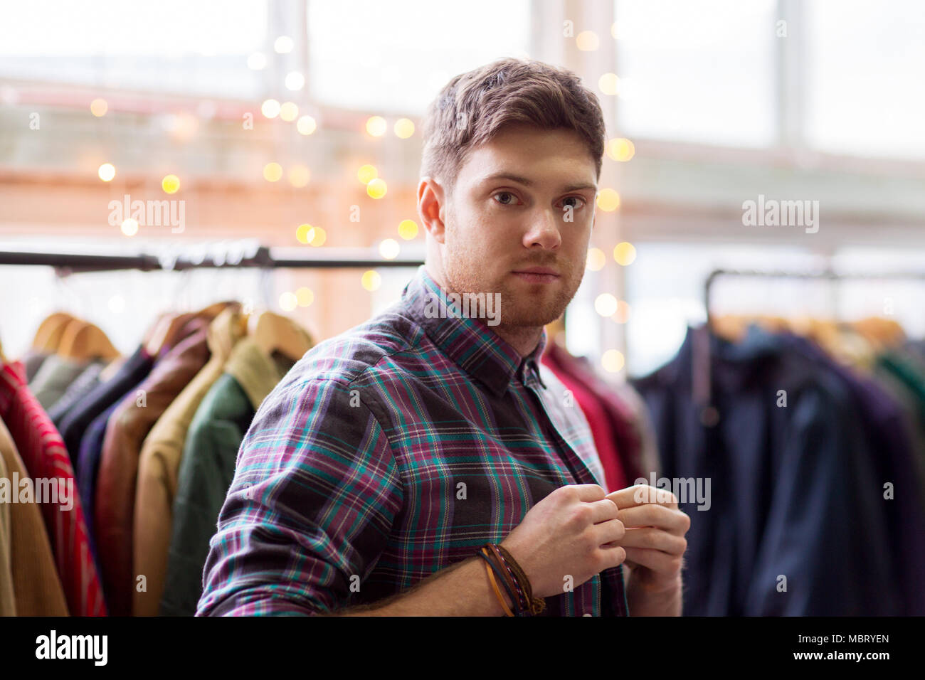man choosing clothes at vintage clothing store Stock Photo - Alamy