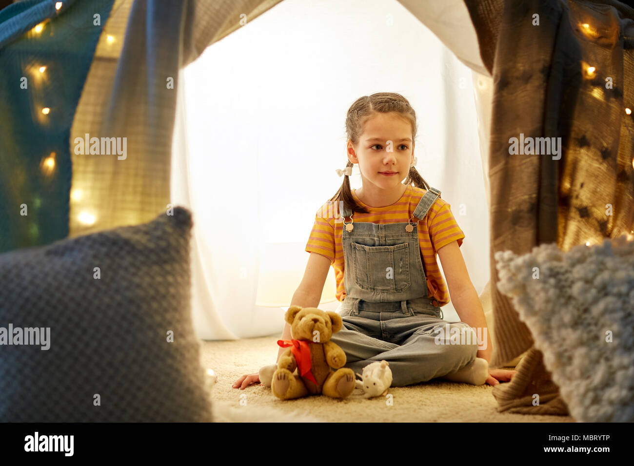 little girl with toys in kids tent at home Stock Photo