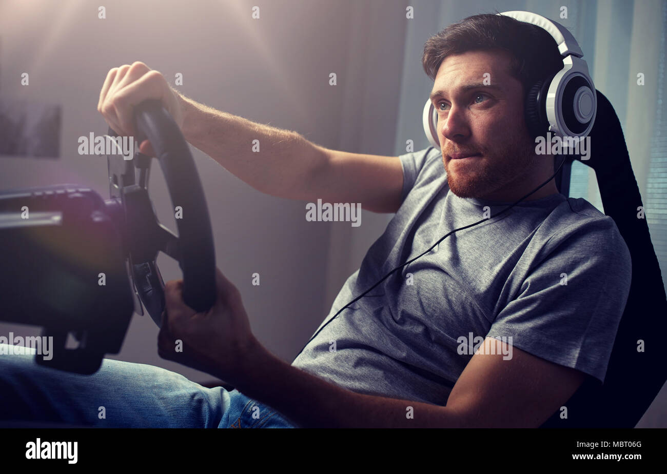 man playing car racing video game at home Stock Photo