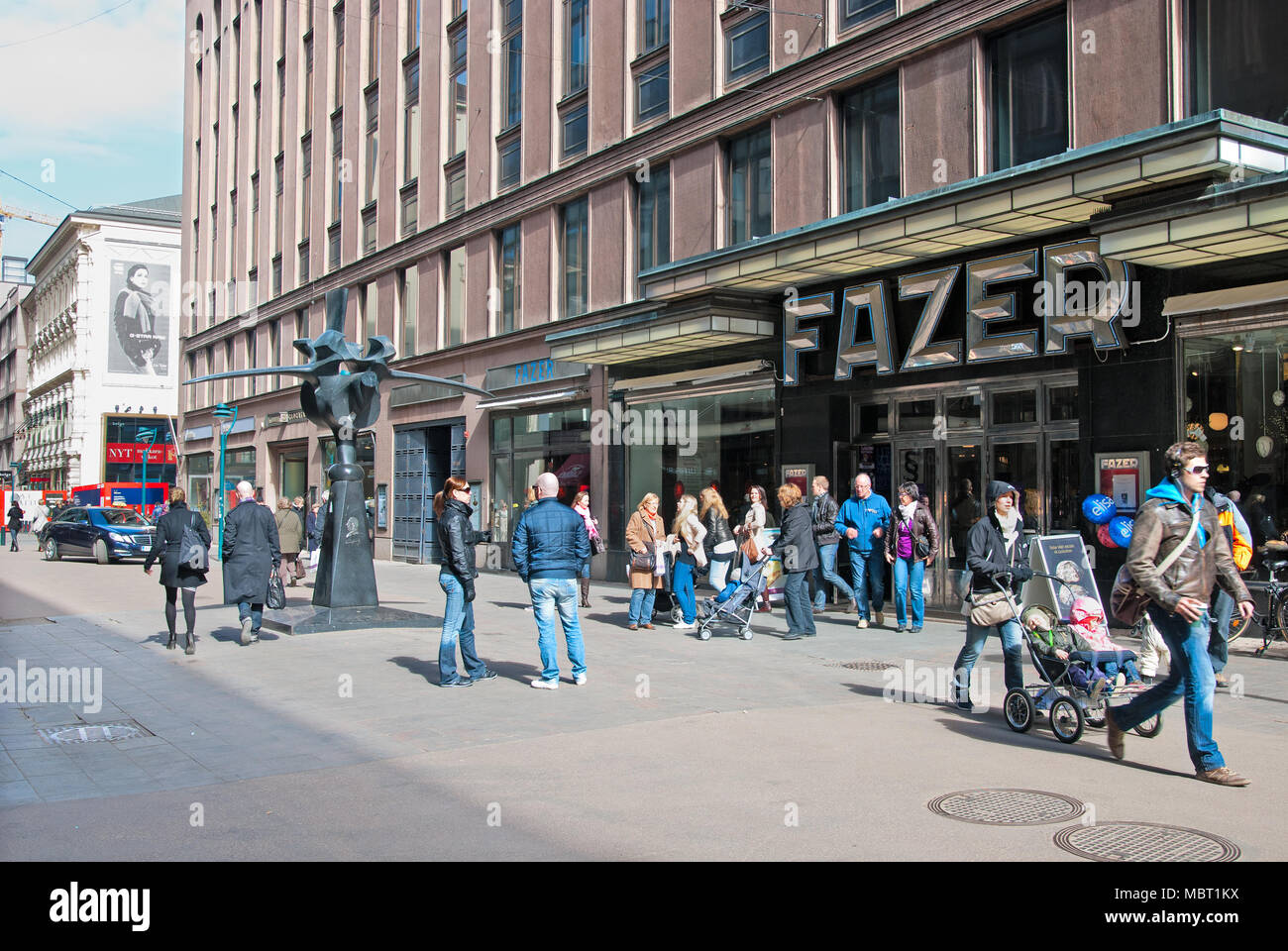 HELSINKI, FINLAND - APRIL 16, 2011: Karl Fazer Cafe. P eople near The shop and cafe of the Fazer Company. Left  is The Fazer Rooster Sculpture Stock Photo