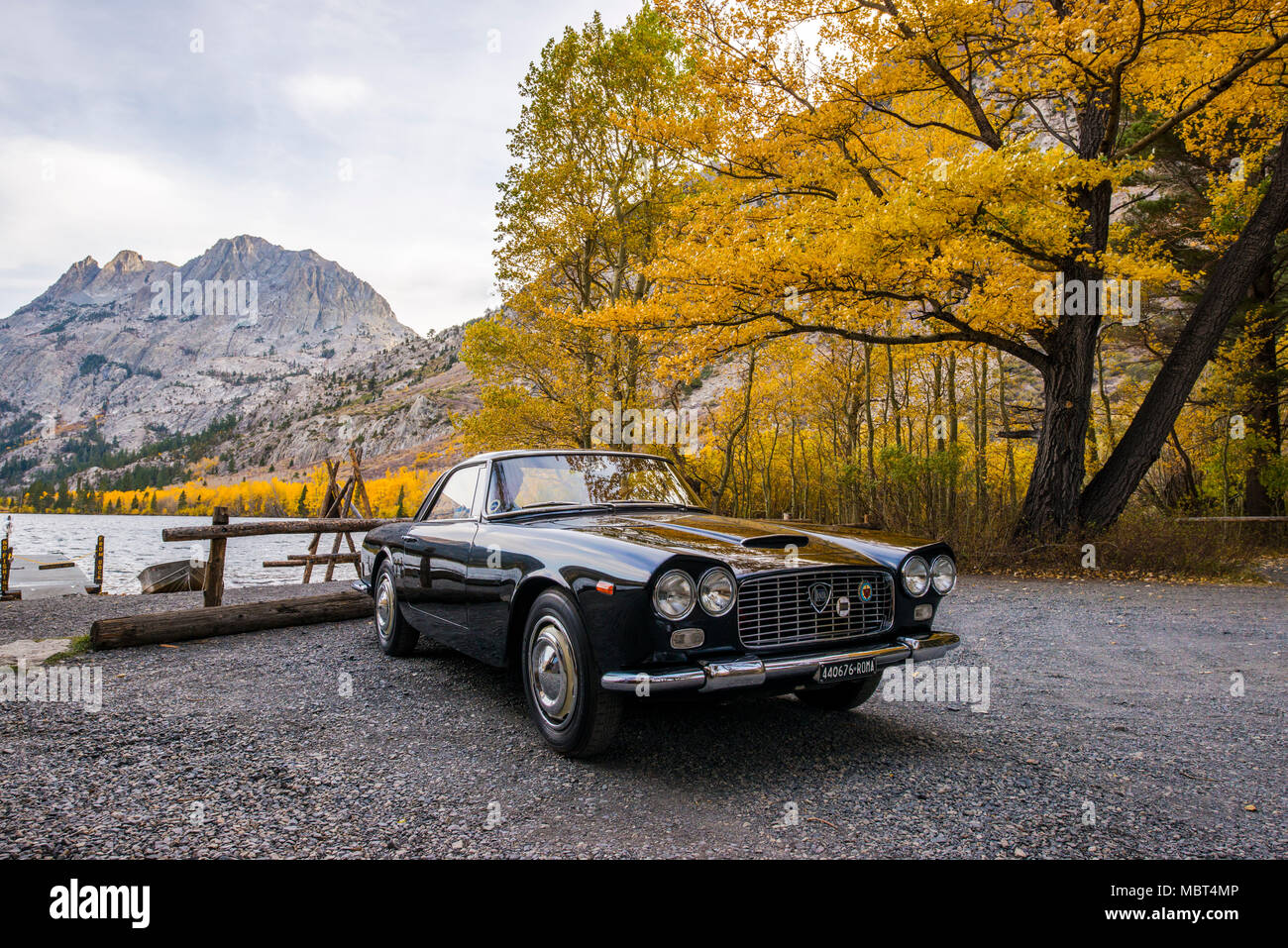 A 1961 Lancia Flaminia car parked in front of Silver Lake along June Lake Loop surrounded by fall color in June Lake, California. Stock Photo