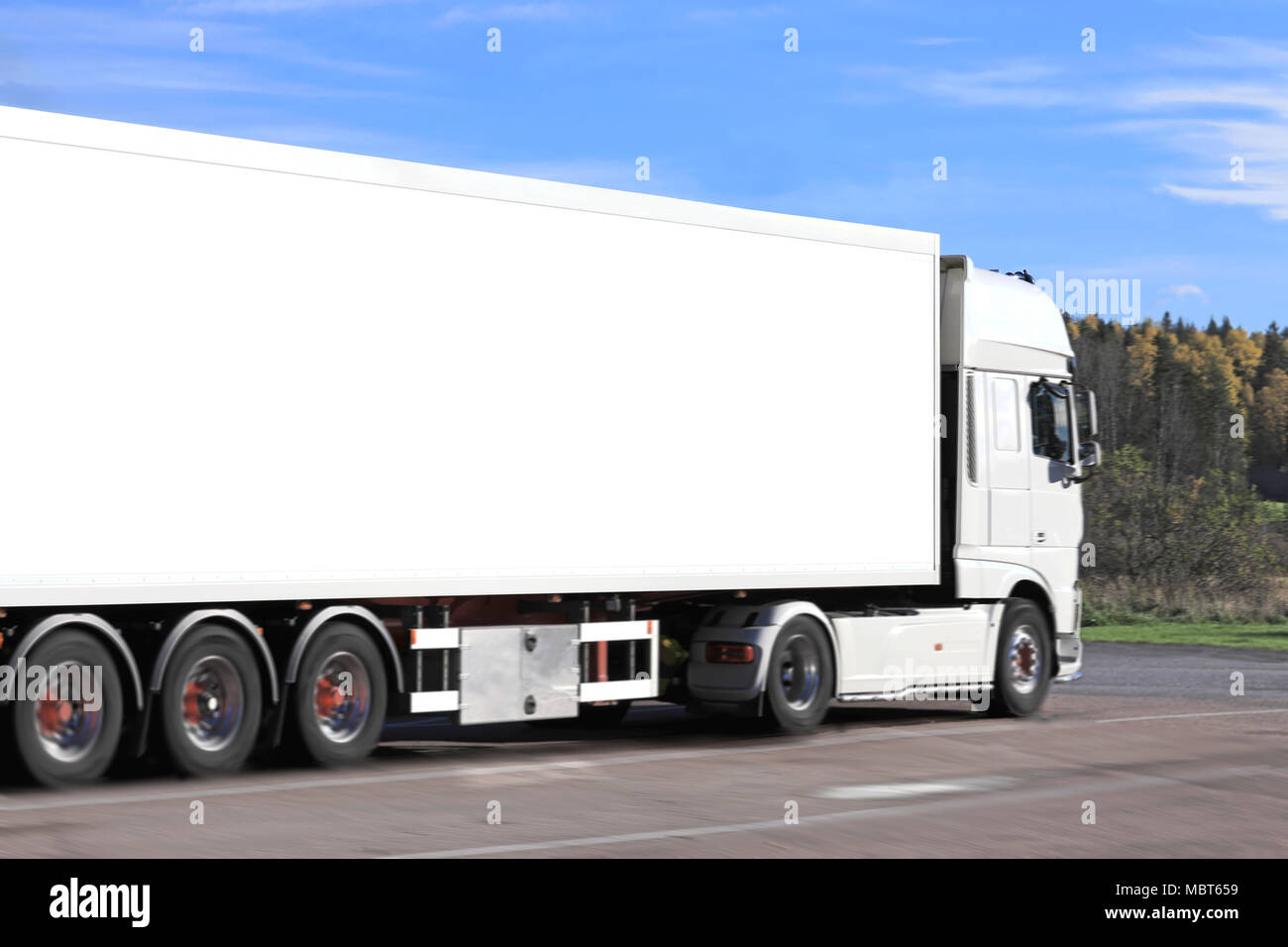 White semi trailer truck in motion, motion blur effects, space for your text. Stock Photo