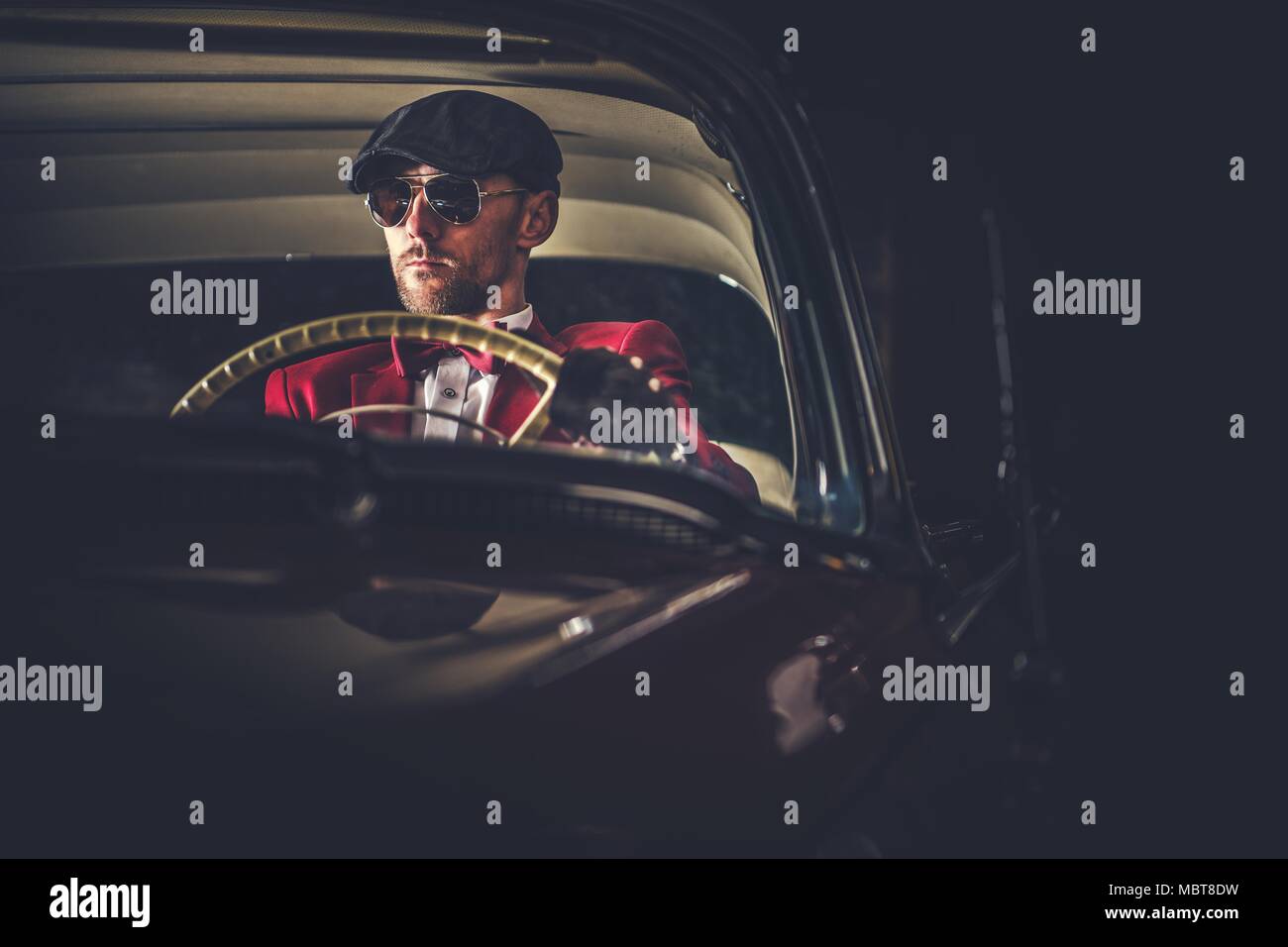 Elegant Caucasian Vintage Car Driver in Sunglasses. Passionate Driving His Classic Car. Stock Photo