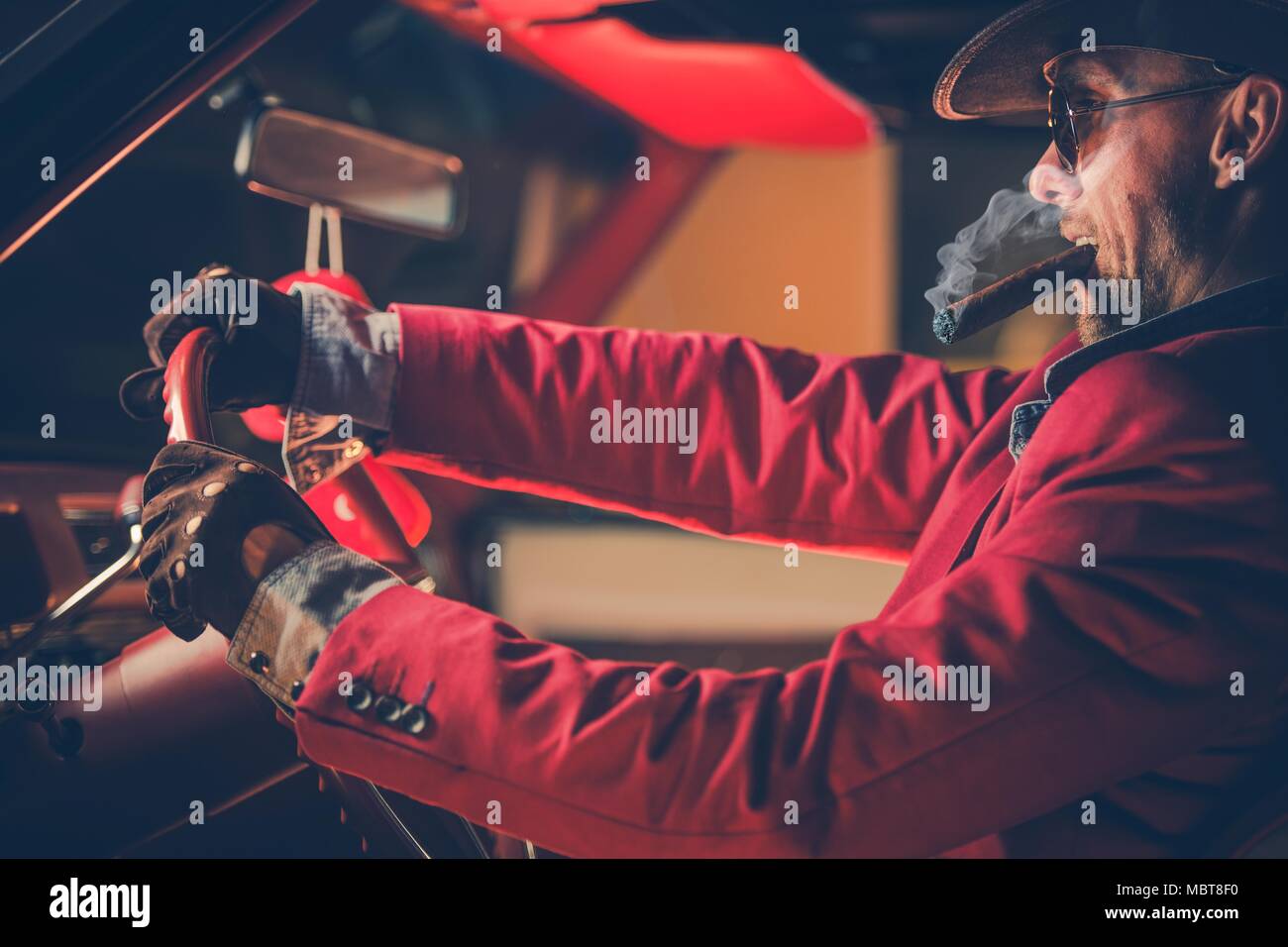 Happy Cowboy Millionaire in His 30s with Burning Cigar in the Vintage Classic Car. American Dream Come True. Lucky Jackpot Winner Leaving Las Vegas. Stock Photo