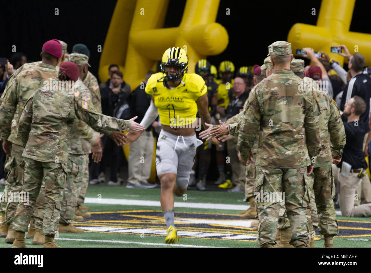 Jaiden Woodbey, an athlete from St. John Boscoe High School in Bellflower, Calif., runs out onto the field during the pre-game events at the U.S. Army All-American Bowl Jan. 6, 2018, in San Antonio, Texas. The All-American Bowl is the nation’s premier high school football game, serving as the preeminent launching pad for America’s future college and National Football League stars. (U.S. Army photo by Sgt. Ian Valley, 345th Public Affairs Detachment/Released) Stock Photo