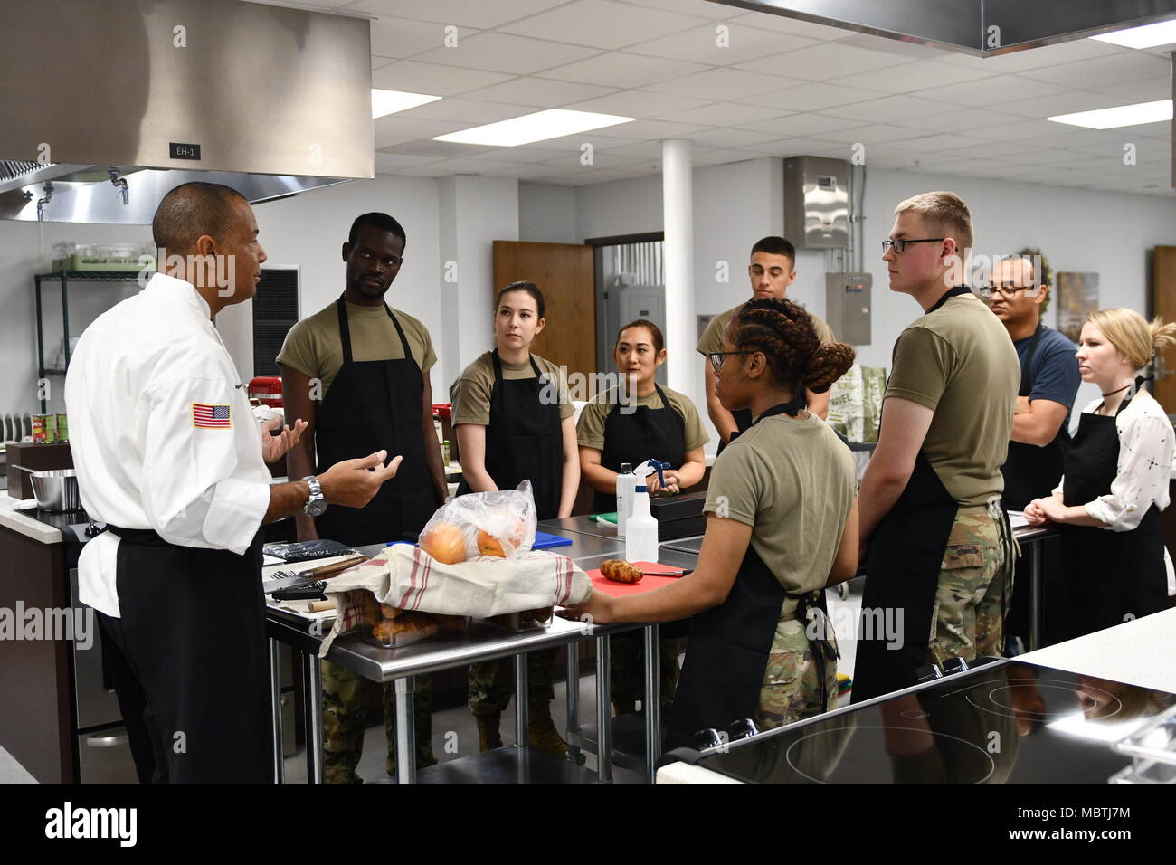 Sgt. 1st Class Raphael B. Bonair, Executive Aide, U.S. Army North (Fifth Army) instruct students about knife utilization at the new teaching kitchen in the Vogel Resiliency Center. The Vogel Resiliency Center is a new facility bringing together eight entities of resiliency services into one location. This facility is unique to Fort Sam Houston and unique in the Army. The grand opening of the Vogel Resiliency Center was January 5, 2018. Stock Photo