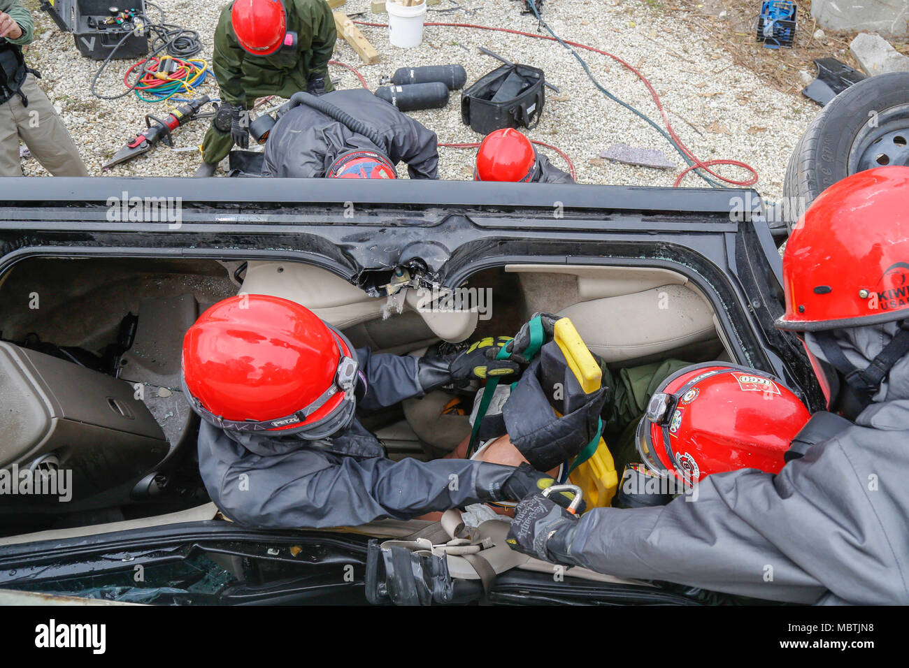 U. S. Army Reserve Soldiers assigned to 424th engineer Company extract a dummy casualty from an overturned vehicle in a Joint Training Exercise on Miami-Dade Fire Rescue Urban Search and Rescue Training Site in Miami, Fla. Jan. 10, 2018. This JTE focused on building response capabilities and seamless transition between the local first responders and the follow-on support provided by the National Guard and Active duty soldiers. (U. S. Army Photo by Spc. Andrea Salgado Rivera) Stock Photo