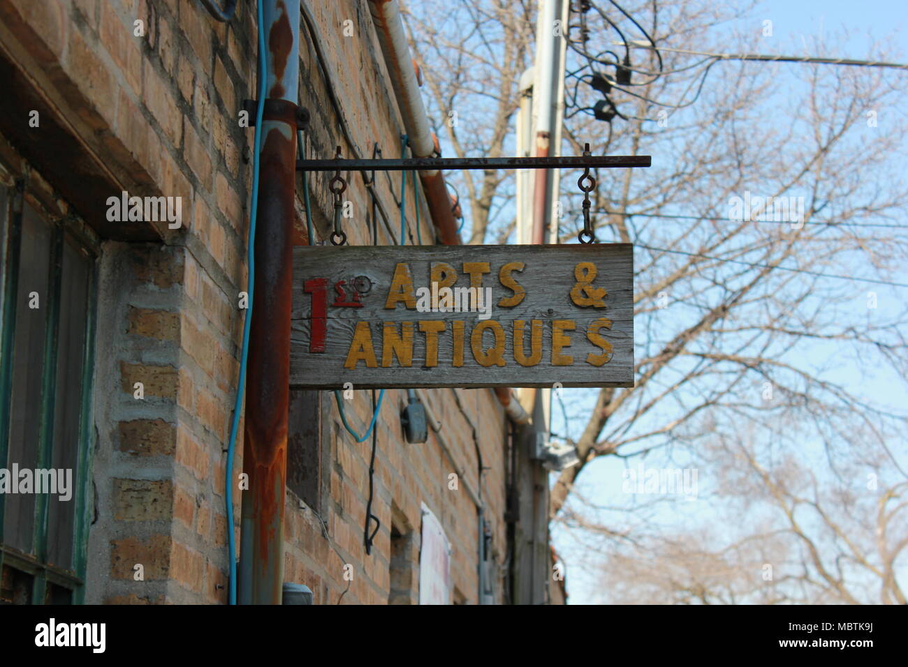 Imagery of a storefront sign " 1st Arts and Antiques" in a commercial
