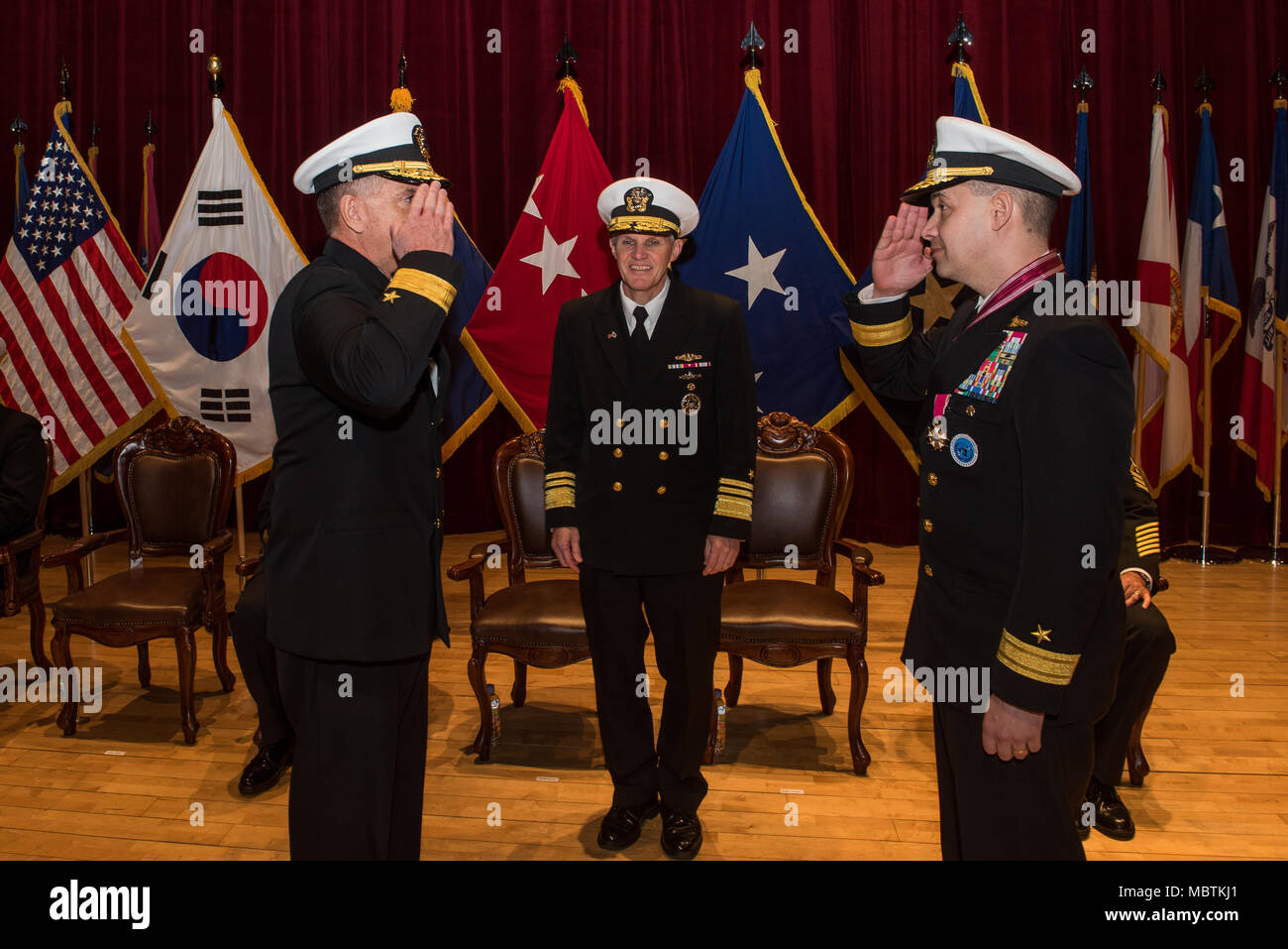 180111-N-TB148-170 Busan, Republic of Korea (Jan 11, 2018) - Rear Adm. Michael E. Boyle renders a salute to Rear Adm. Brad Cooper in front of Vice Adm. Phil J. Sawyer, commander, U.S. Seventh Fleet, assuming command of U.S. Naval Forces Korea (CNFK). During the ceremony Rear Adm. Michael E. Boyle relieved Rear Adm. Brad Cooper, becoming CNFK’s 36th commander. (U.S. Navy photo by Mass Communication Specialist Seaman William Carlisle) Stock Photo