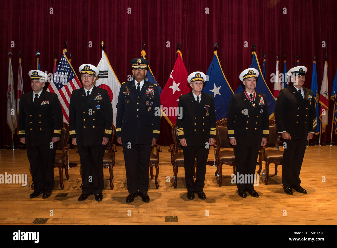 180111-N-TB148-044 Busan, Republic of Korea (Jan 11, 2018) - The official party stands at attention prior to the parading of the colors during a change of command ceremony at Commander, U.S. Naval Forces Korea headquarters. During the ceremony Rear Adm. Michael E. Boyle relieved Rear Adm. Brad Cooper, becoming CNFK’s 36th commander. (U.S. Navy photo by Mass Communication Specialist Seaman William Carlisle/ Released) Stock Photo