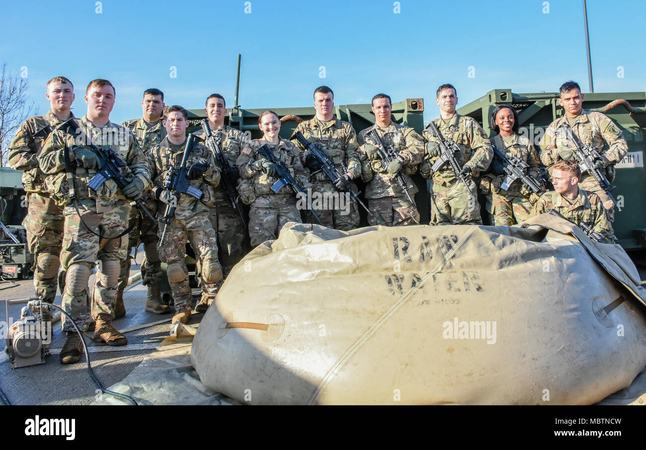 The Water Purification Platoon from the Brigade Support Battalion, 173rd Airborne Brigade, stands proudly with their equipment and filtered water. Stock Photo