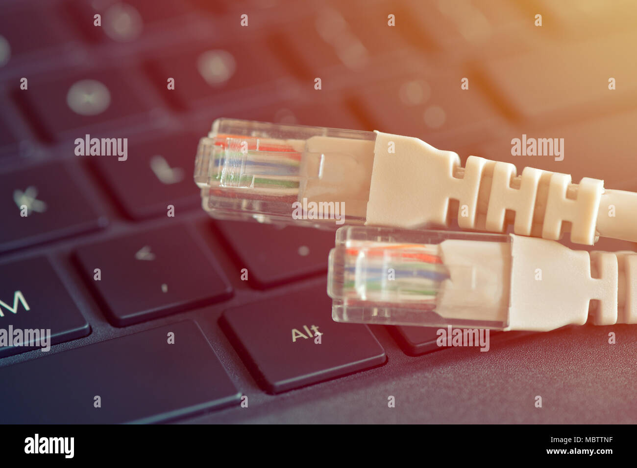 Internet cable lies on the keyboard. Concept technologies and Internet connection Stock Photo