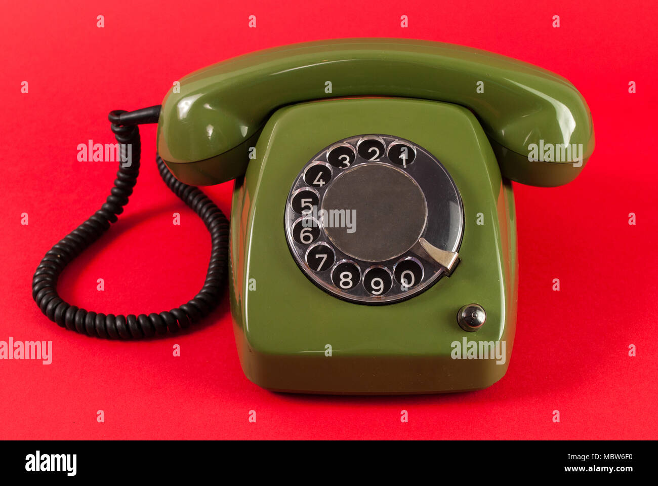 Old retro green rotary phone isolated on red background Stock Photo