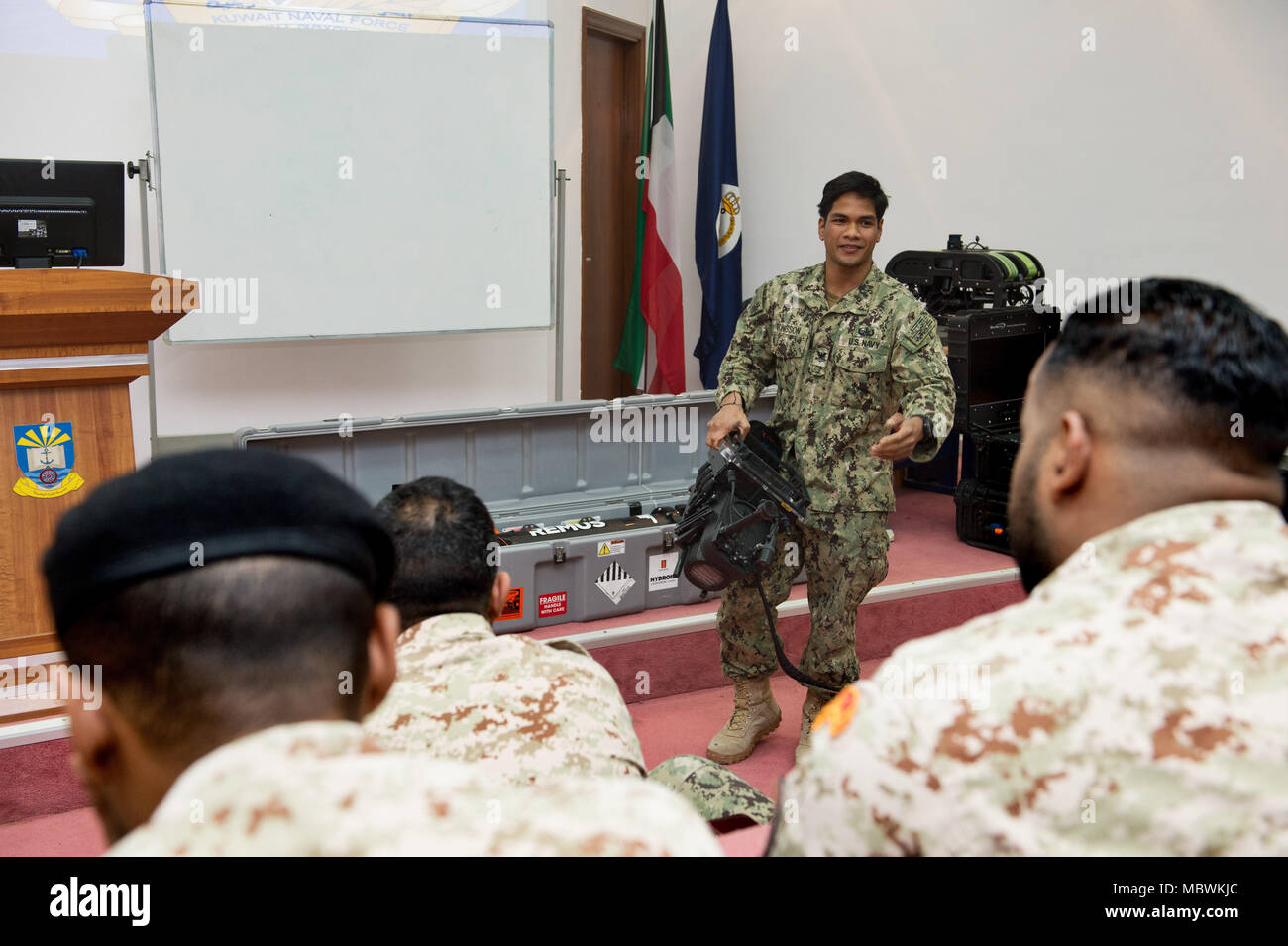 180107-N-XE158-0078 Mohammed Al-Ahmad Naval Base, KUWAIT (Jan. 7, 2018) Explosive Ordnance Disposal Technician 2nd Class Veranio-Xavier Tongson, assigned to Commander, Task Group 56.1, explains the capabilities of an underwater navigation system to Kuwait Naval Force explosive ordnance disposal technicians during a training evolution as part of exercise Eager Response 18. Eager Response 18 is a bilateral explosive ordnance disposal military exercise between the State of Kuwait and the United States. The exercise fortifies military-to-military relationships between the Kuwait Naval Force and U. Stock Photo