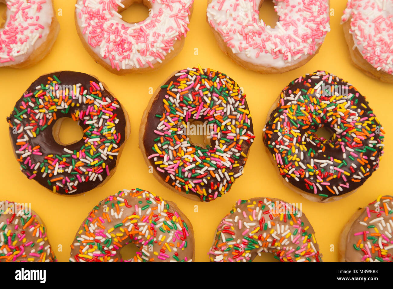 Sprinkle Donuts on a Yellow Background Stock Photo
