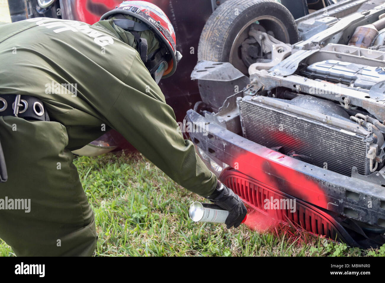 A Soldier assigned to the 414th Chemical Company from Orangeburg, South Carolina marks vehicles with identification symbols, signaling the type of simulated casualty located within during a Joint Training Exercise hosted by the Homestead-Miami Speedway and Miami-Dade Fire Department in Miami, Florida. Jan. 11, 2018. This JTE focused on building response capabilities and the seamless transition between the local first responders and the follow-on support provided by the National Guard and Active duty soldiers. (U. S. Army Photo by Spc. Samuel Brooks) Stock Photo