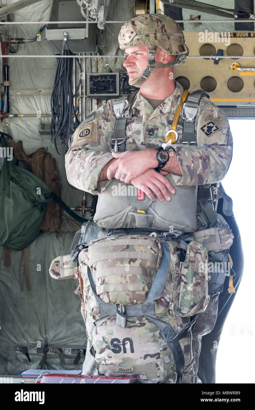 POPE ARMY AIRFIELD, N.C. — A Soldier with the Army's 27th Engineer Battalion (Airborne) waits for fellow paratroopers on the back of a Georgia Air National Guard C-130H Hercules on Green Ramp during joint airdrop training here Jan. 10, 2018. The aircraft and crew are from the 165th Airlift Wing in Savannah, Ga. Airmen in the 43d Air Mobility Squadron and 43d Air Base Squadron here supported both visiting aircrews and Army units throughout the training. The 43d Air Mobility Operations Group, which is part of Air Mobility Command, powers airlift training and real-world operations for Army and Ai Stock Photo