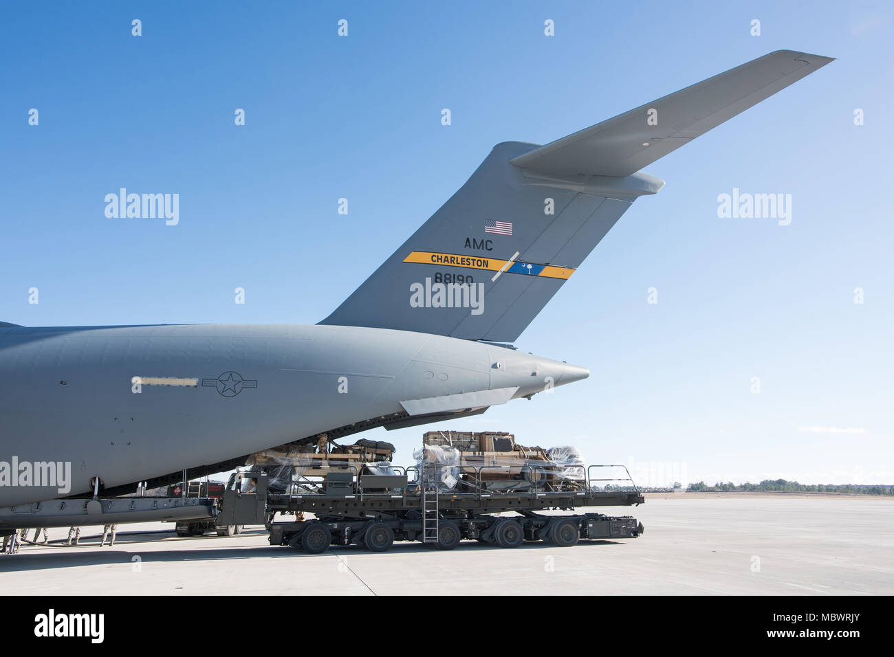 POPE ARMY AIRFIELD, N.C. — Airmen and Soldiers prepare to load cargo on a 437th Airlift Wing C-17 Globemaster III during joint airdrop training on Green Ramp here Jan. 10, 2018. Airmen in the 43d Air Mobility Squadron and 43d Air Base Squadron here supported both visiting aircrews and Army units throughout the training. The 43d Air Mobility Operations Group, which is part of Air Mobility Command, powers airlift training and real-world operations for Army and Air Force conventional and special operations units at Fort Bragg, moving millions of pounds of cargo and thousands of passengers each ye Stock Photo