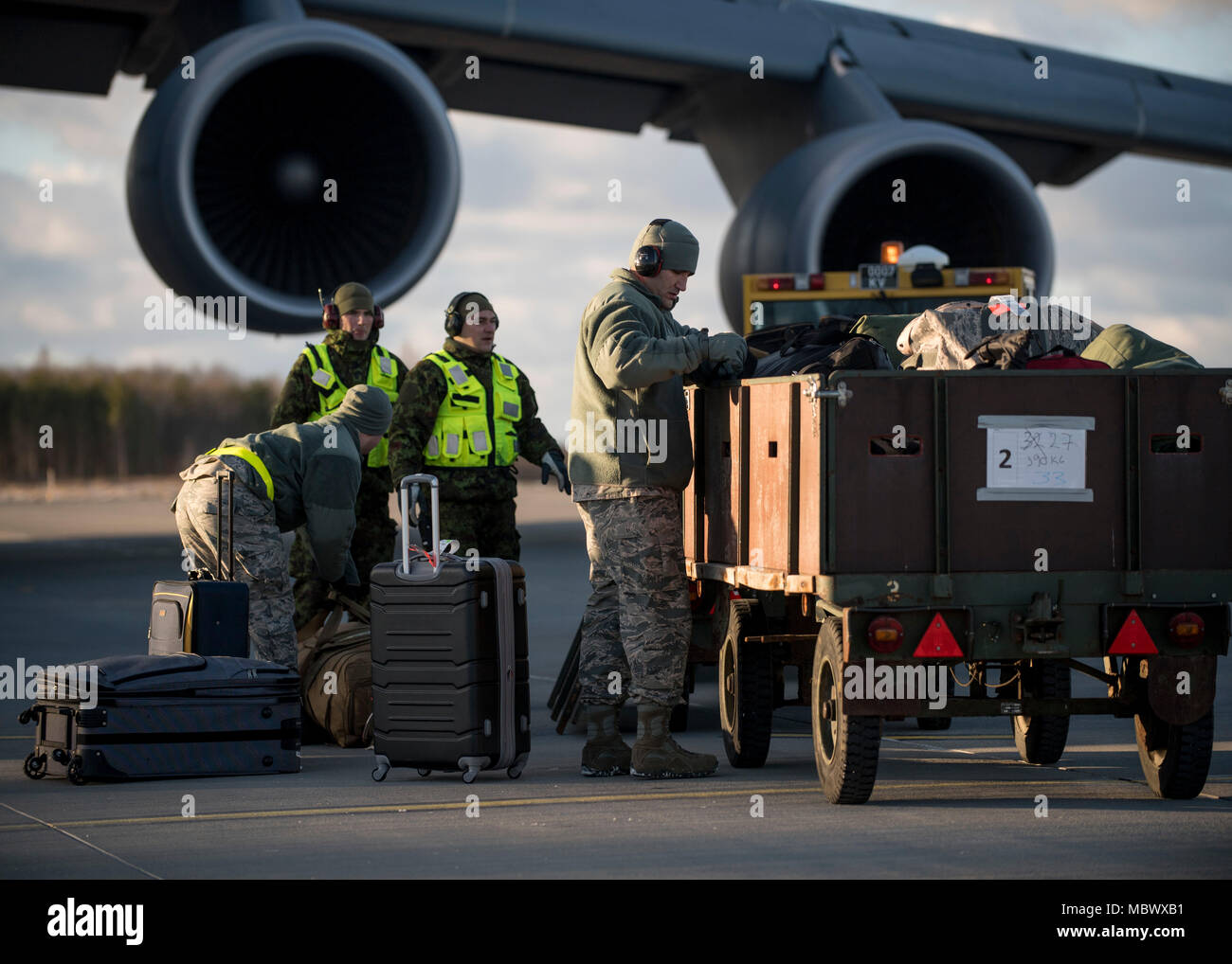 180108-N-YO638-123 AMARI AIR BASE, ESTONIA (Jan. 8, 2018) – U.S. and Estonian Airmen work together to unload supplies from a C-5 Galaxy cargo plane in support of Theater Security Package 18.1, January 8th, 2018. This TSP highlights the U.S.’s ability to deploy fighter aircraft in support of our partners and allies in the European theater and around the world. (DoD photo by MC3 Cody Hendrix/Released) Stock Photo