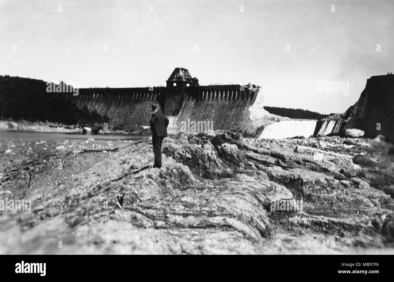 22 January 2018, Möhnesee, Germany: A man standing in front of the destroyed dam of Moehne valley. On the night of May 17th 1943, British Royal Air Forces bombed the Moehne Dam, using a special bomb developed for this purpose. The bombardment resulted in a huge tidal wave, that rolled from Möhnesee through the Ruhr Valley to the Ruhr area. Photo: Julian Stratenschulte/dpa Stock Photo