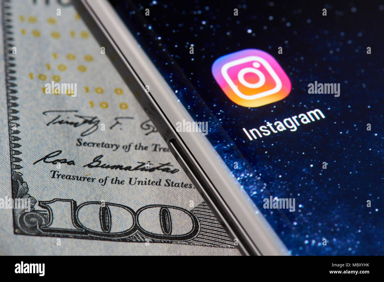 New york, USA - April 11, 2018: Instagram icon app on smartphone close-up on dollar currency background Stock Photo