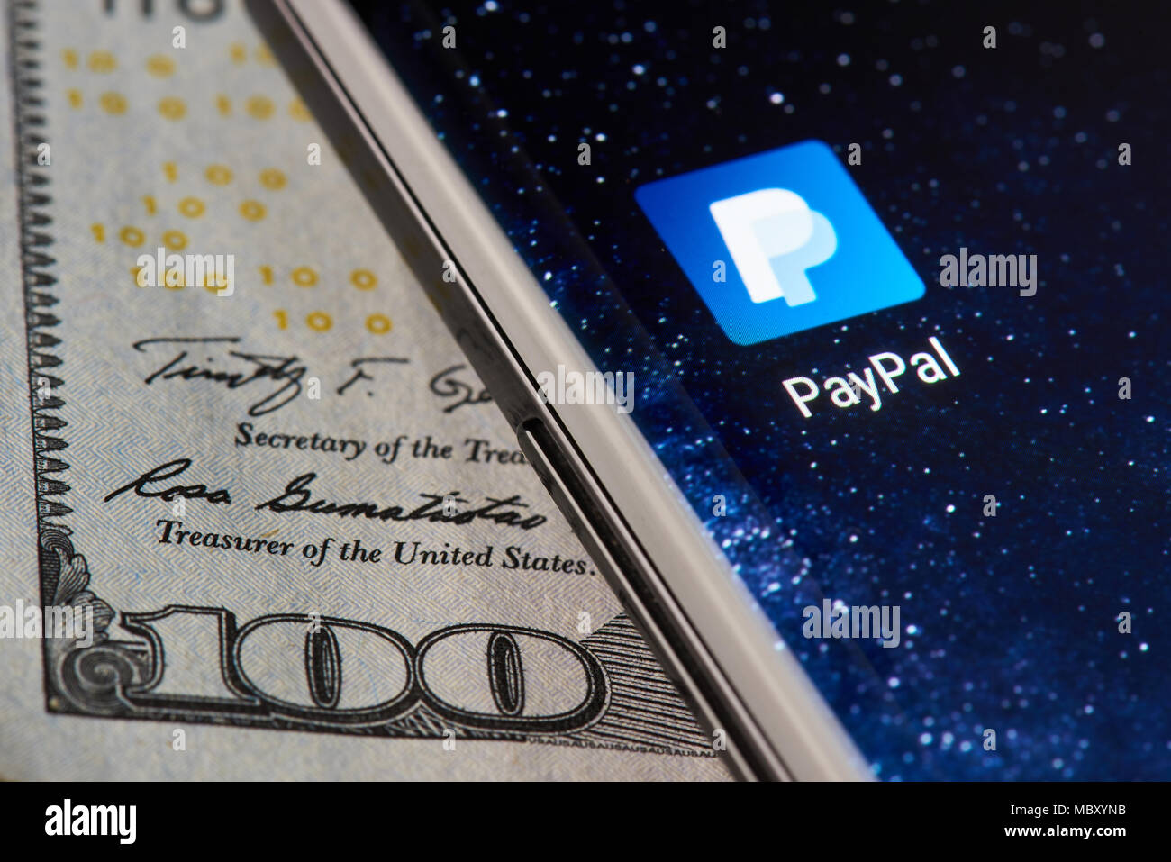 New york, USA - April 11, 2018: Paypal icon app on smartphone close-up on dollar currency background Stock Photo