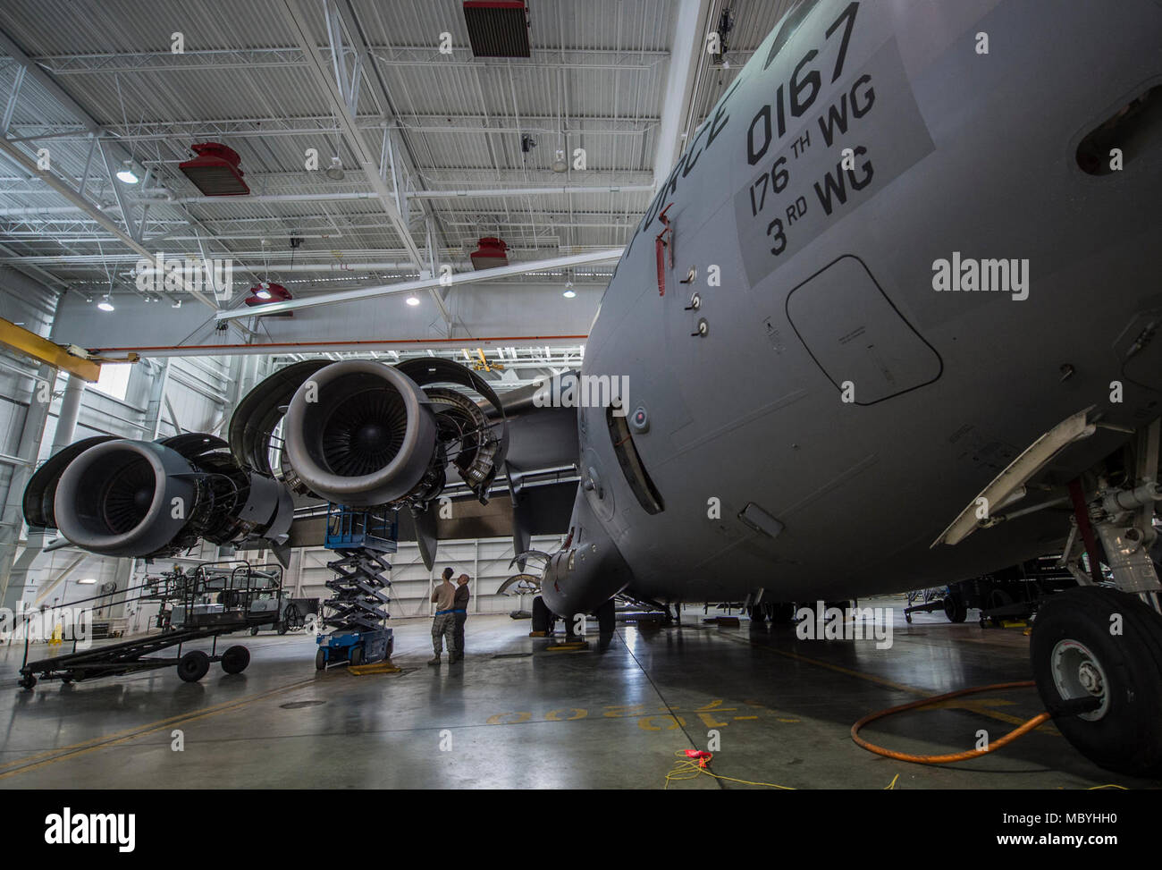 A C-17 Globemaster III assigned to the 176th Wing sits inside a hangar for a home station check at Joint Base Elmendorf-Richardson, Alaska, March 27, 2018. The 3rd and 176th maintenance squadrons complete an in-depth, four-day scheduled inspection of a C-17 approximately every 180 days. A home station check is the behind-the-scenes maintenance that can prevent loss of life, lead to savings in time and money and keep the aircraft fit to fight. Stock Photo