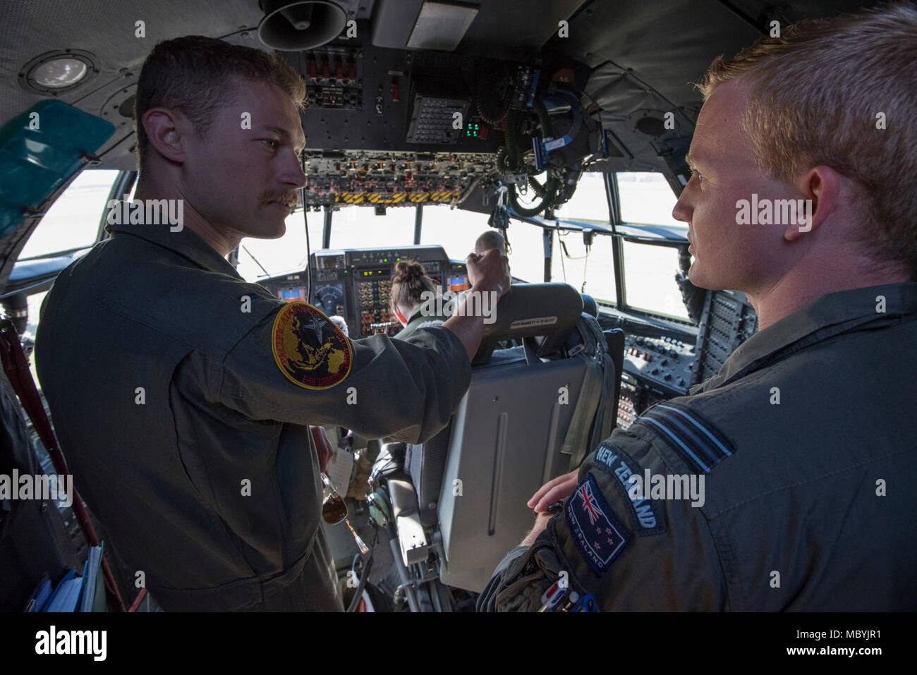 First Lt. Taylor Absher, 14th Fighter Squadron F-16 pilot (left), receives a tour of a Royal New Zealand Air Force C-130 Hercules at Wanaka Airport, New Zealand, March 30, 2018. U.S. forces are participating in Warbirds over Wanaka Airshow 2018 to strengthen military-to-military ties with New Zealand partners while enhancing relationships with partners in the Indo-Pacific region. Aerial events like WOW Airshow 2018 provide the U.S. An opportunity to strengthen its international partnerships and military-to-military relationships with allies and partners throughout the region. Stock Photo