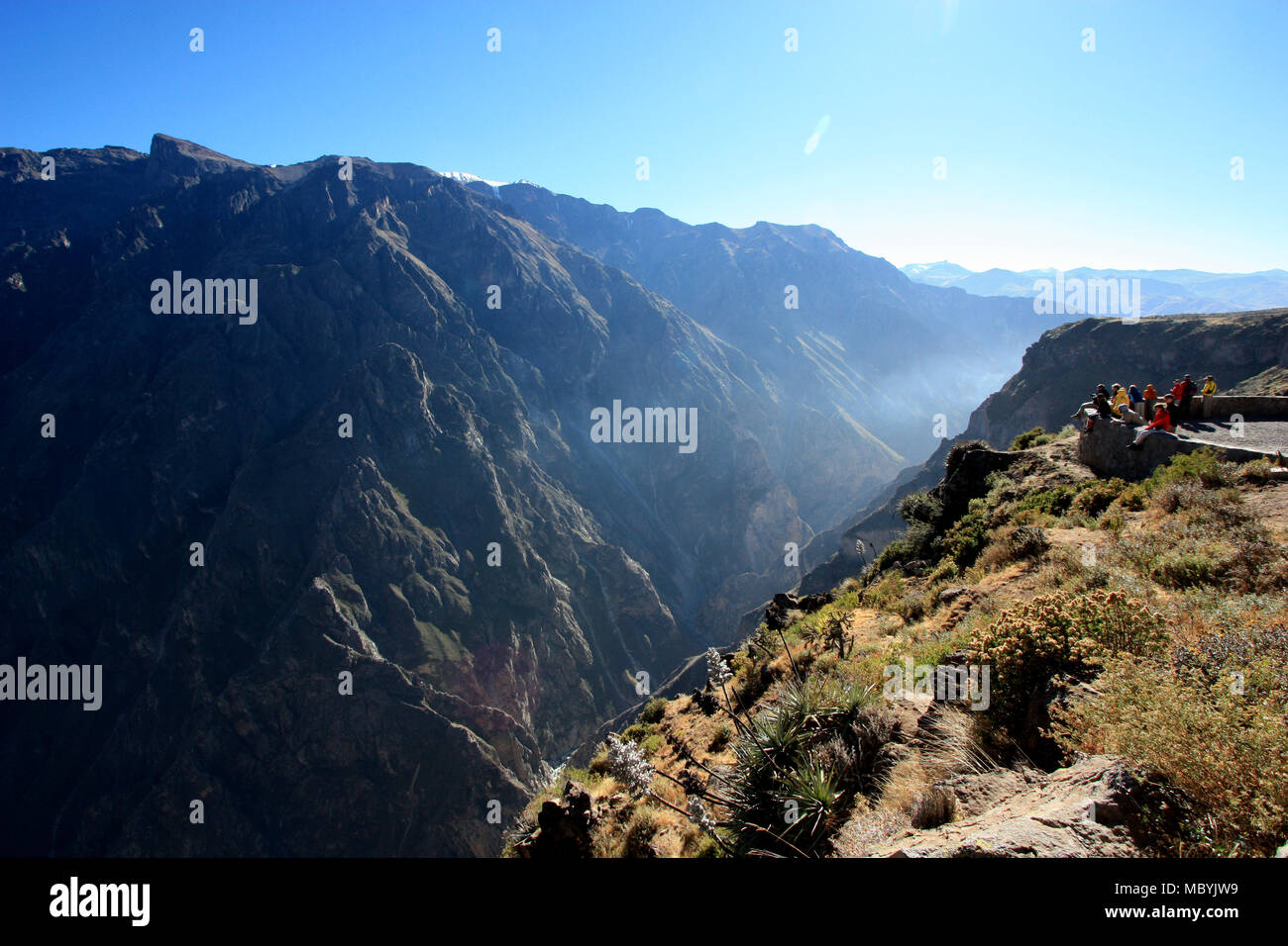Tourists looking into the Colca Canyon in the Andes Mountain Range near Chivay, Peru, which is the deepest Canyon on the Planet. Stock Photo