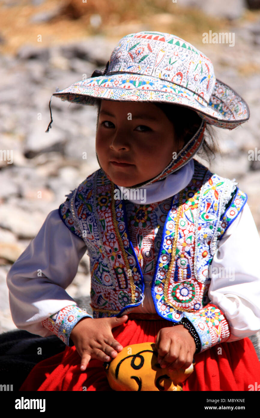 A little Girl with traditional Peruvian Clothes smiling into the Camera. Maca, Peru Stock Photo