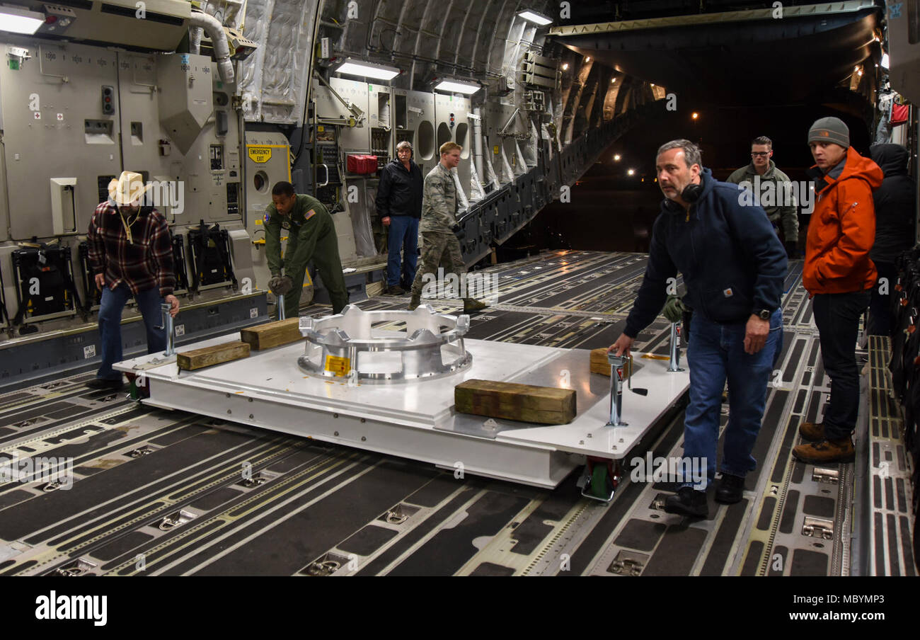 89th Aerial Port Squadron and 3rd Airlift Squadron Airmen, along with NASA employees, move a load dolly into a C-17 Globemaster III on Joint Base Andrews, Md., April 3, 2018. The load dolly is used as a staging platform for the Parker Solar Probe so NASA employee scan operate on the spacecraft. Stock Photo
