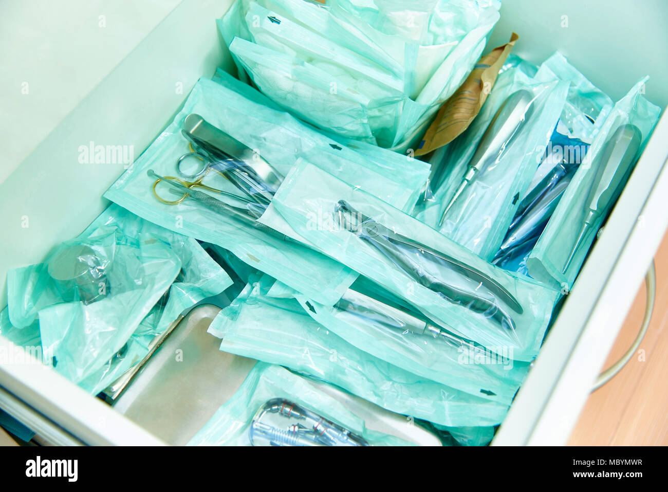 Sterile sealed dental instruments are stacked in a drawer Stock Photo