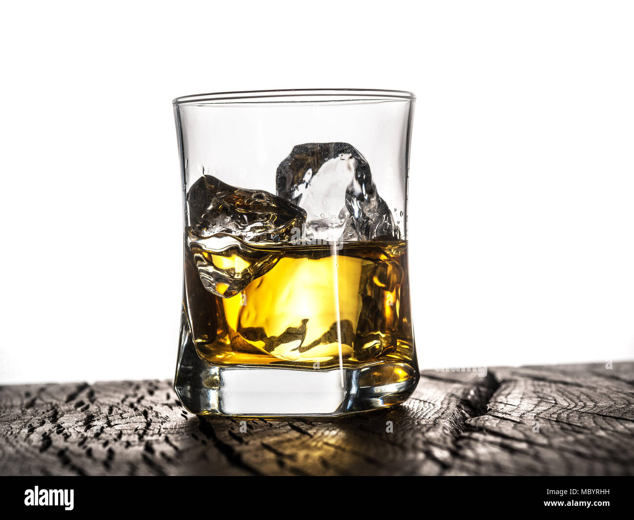 Whiskey glass or glass of whiskey with ice cubes on table at the white background. Stock Photo