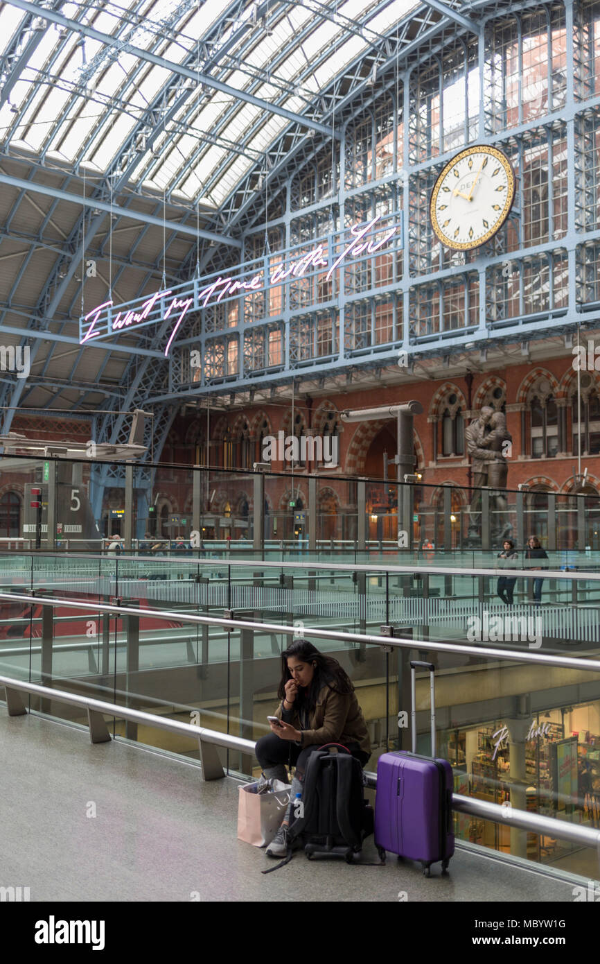 The new artwork entitled 'I Want My Time With You' by British (Britpop) artist Tracy Emin hangs over the main concourse at St. Pancras Station, on 10th April 2018, in London, England. In the sixth year of the Terrace Wires Commission - and in celebration of the 150th anniversary of St Pancras International and the 250th anniversary of the Royal Academy of Arts, at one of London's mainline station, the London hub for Eurostar - the 20 metre-long greeting to commuters reads 'I Want My Time With You' and Emin thinks that arriving by train and being met by a lover as they put their arms around the Stock Photo