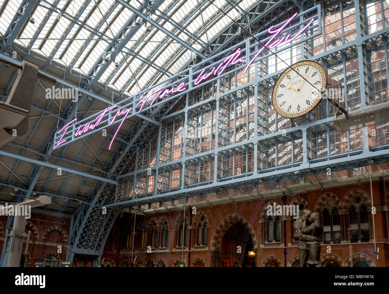 The new artwork entitled 'I Want My Time With You' by British (Britpop) artist Tracy Emin hangs over the main concourse at St. Pancras Station, on 10th April 2018, in London, England. In the sixth year of the Terrace Wires Commission - and in celebration of the 150th anniversary of St Pancras International and the 250th anniversary of the Royal Academy of Arts, at one of London's mainline station, the London hub for Eurostar - the 20 metre-long greeting to commuters reads 'I Want My Time With You' and Emin thinks that arriving by train and being met by a lover as they put their arms around the Stock Photo
